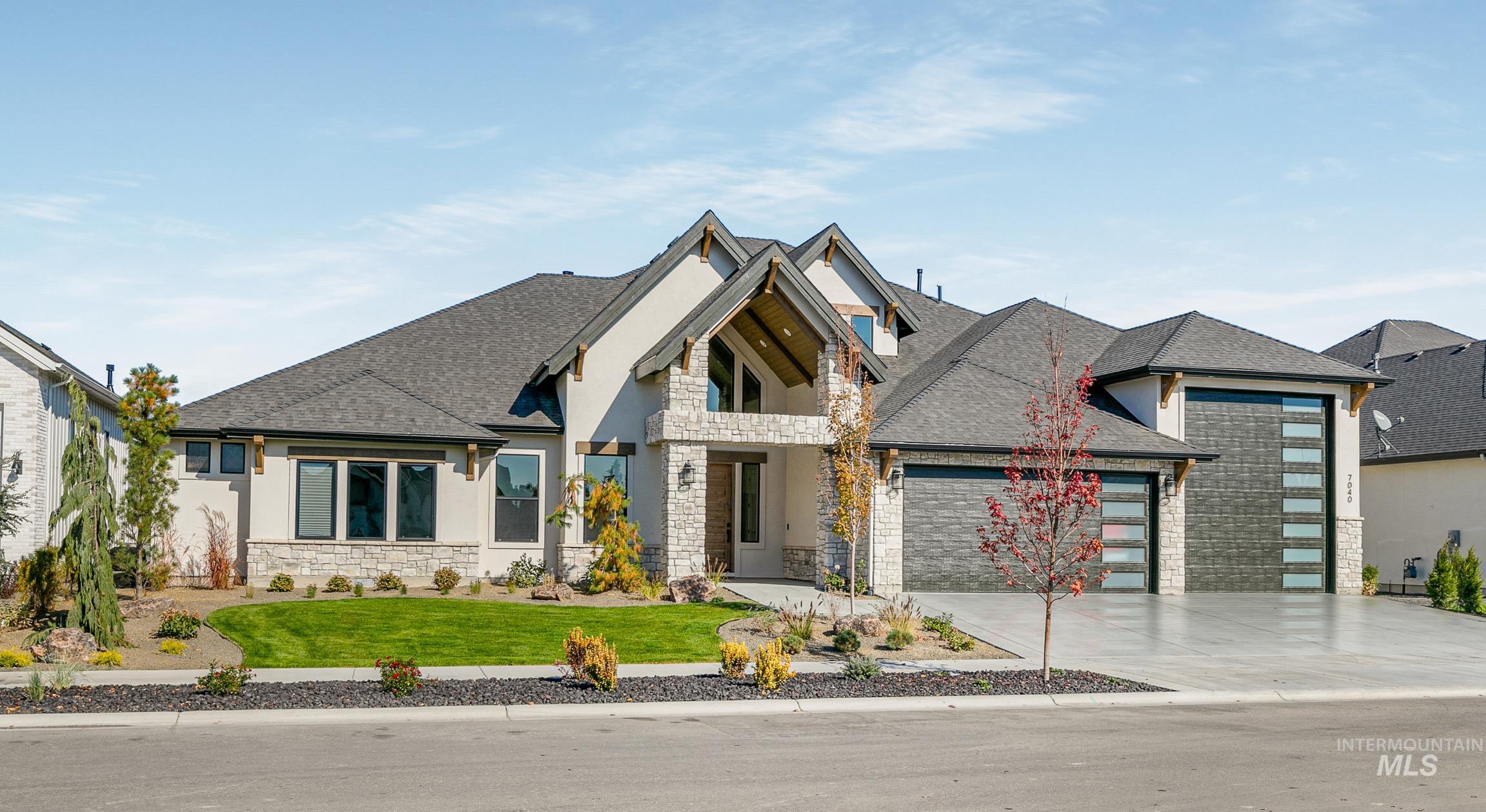 Contemporary house with stone siding, a shingled roof, a front yard, and an attached garage