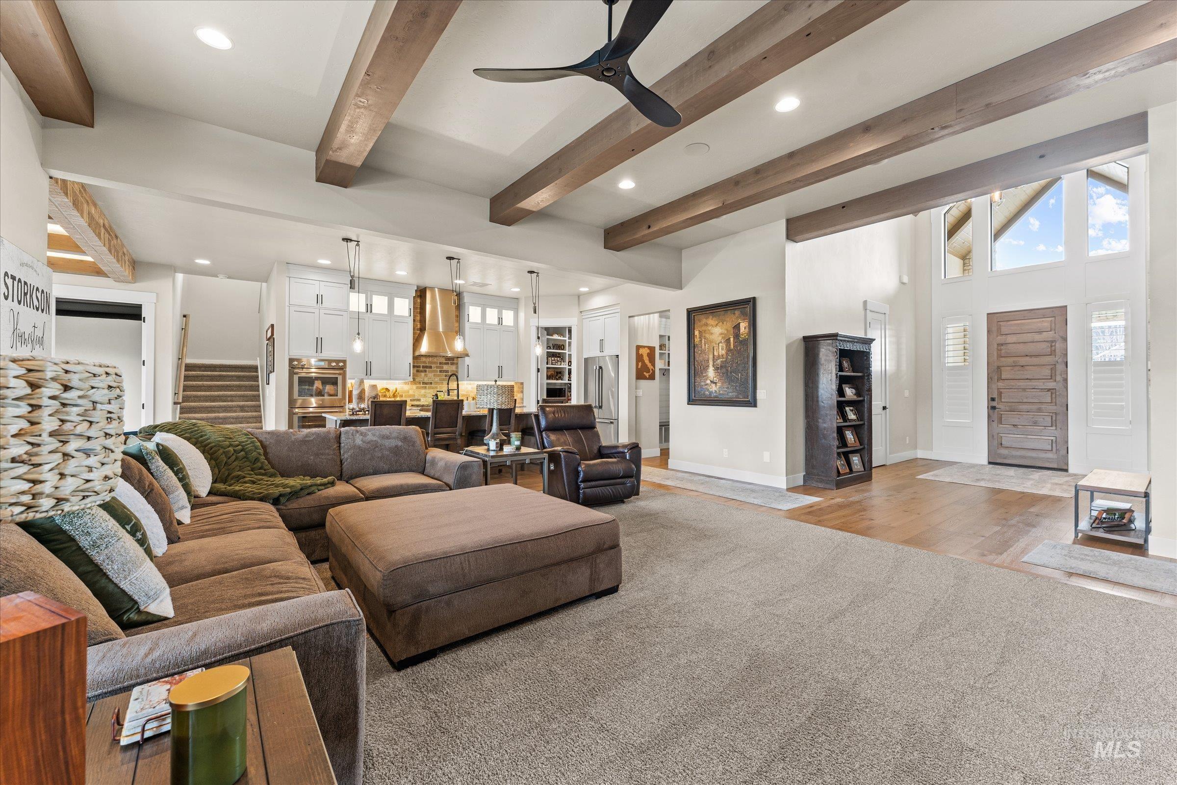 Living area featuring recessed lighting, ceiling fan, carpet flooring, and beam ceiling