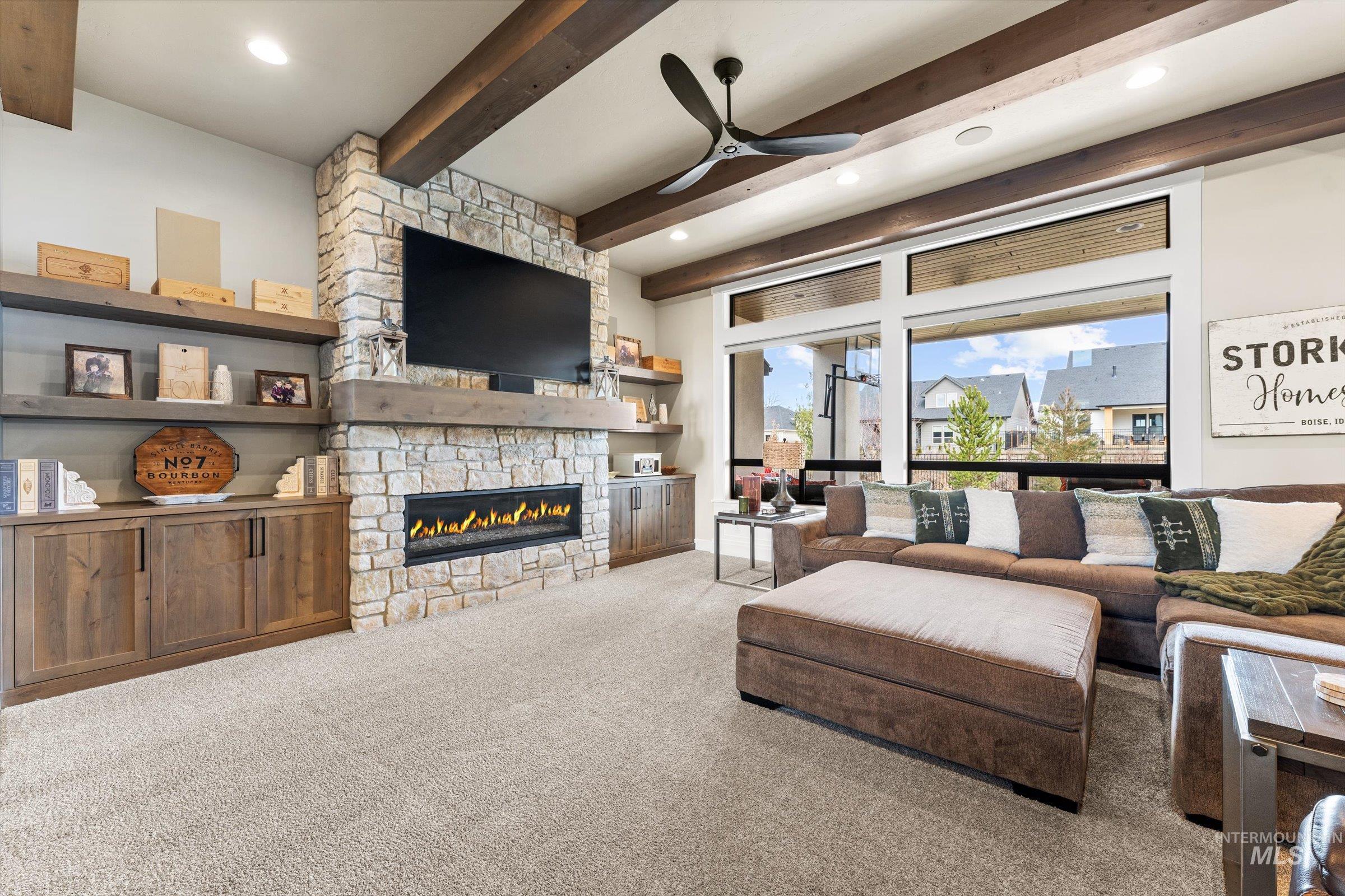 Living area with ceiling fan, carpet, beam ceiling, a fireplace, and recessed lighting