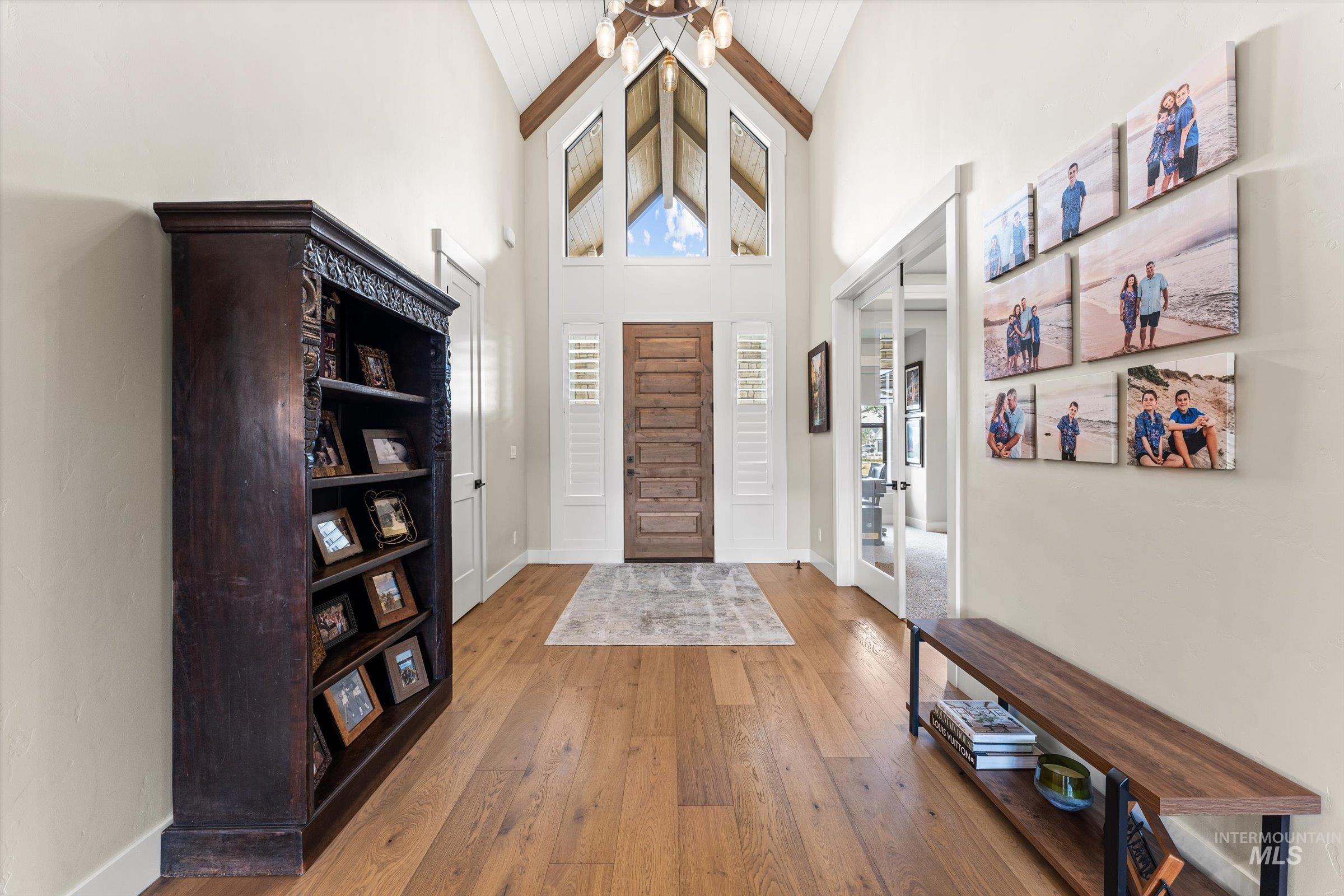 Foyer with light wood-style flooring and vaulted ceiling