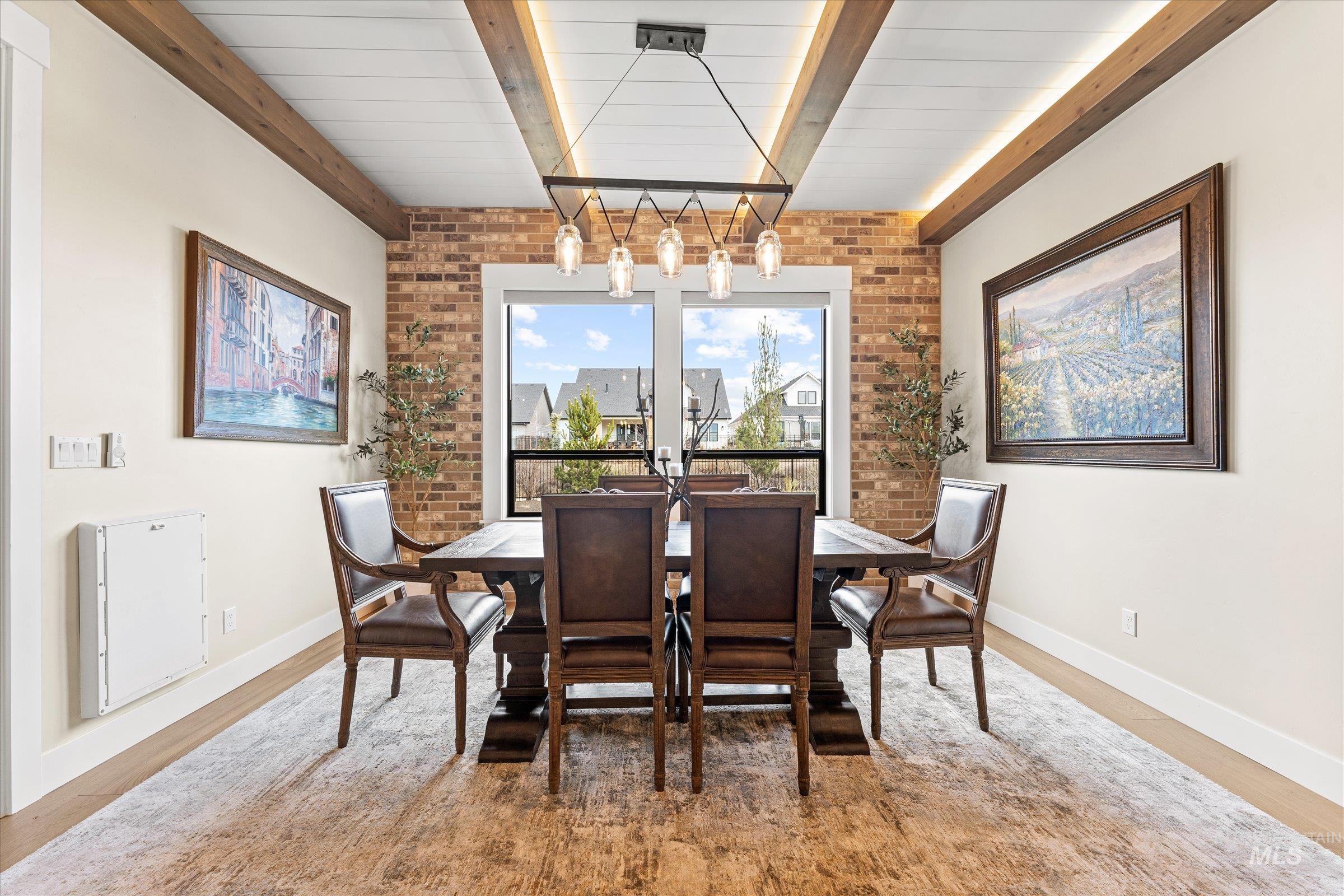 Dining space featuring brick wall and beam ceiling