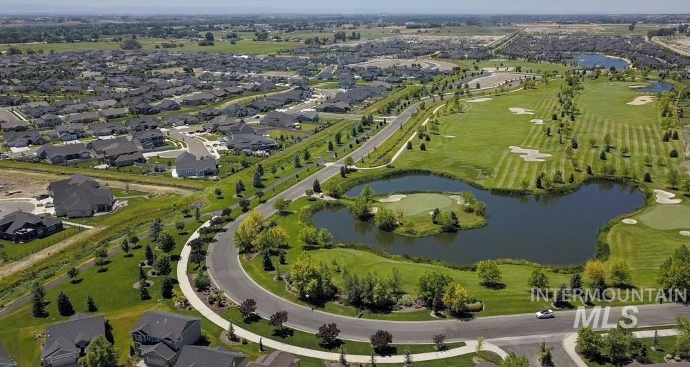 Aerial overview of property's location featuring a large body of water, nearby suburban area, and a golf club