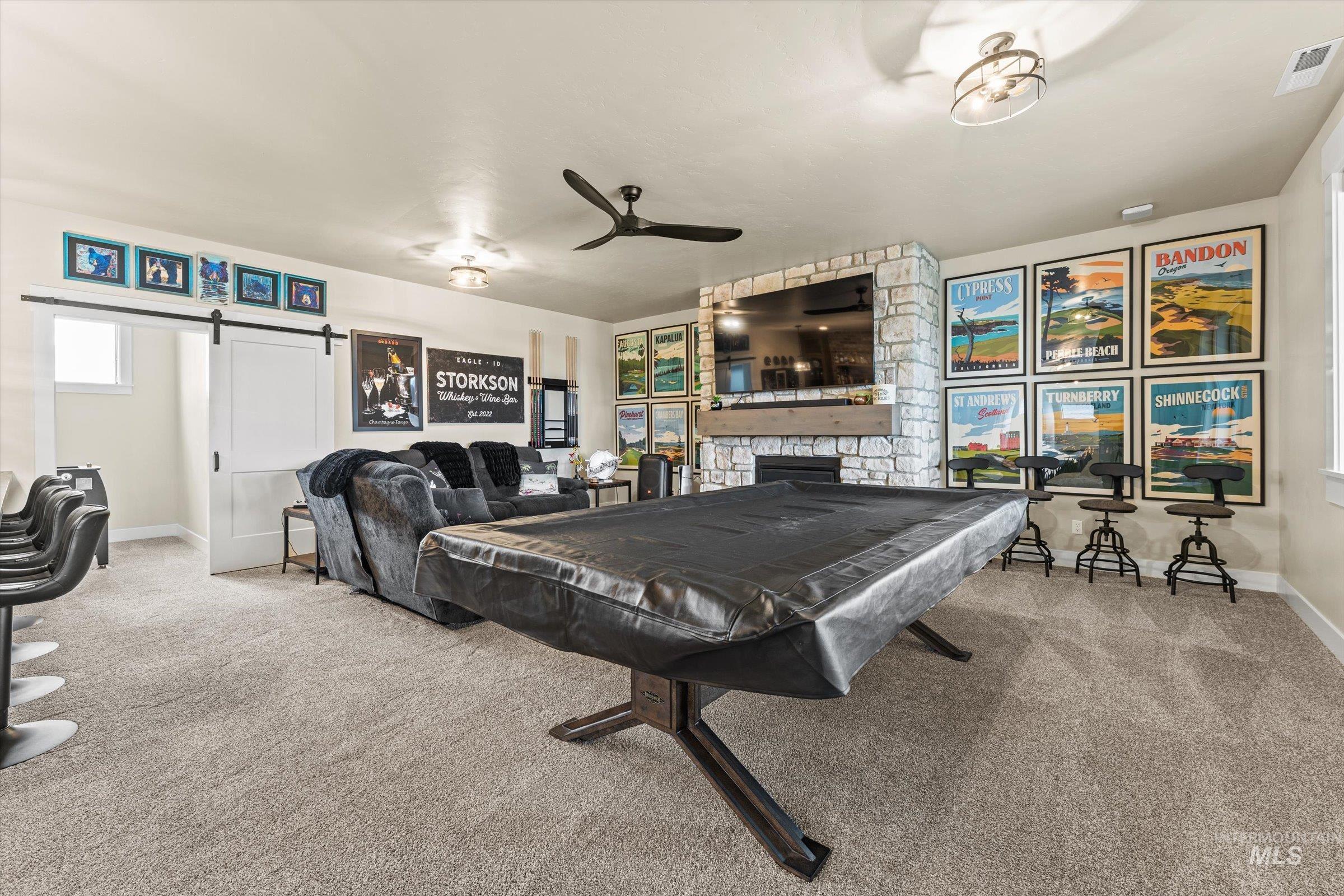 Playroom with a barn door, a fireplace, carpet floors, and billiards