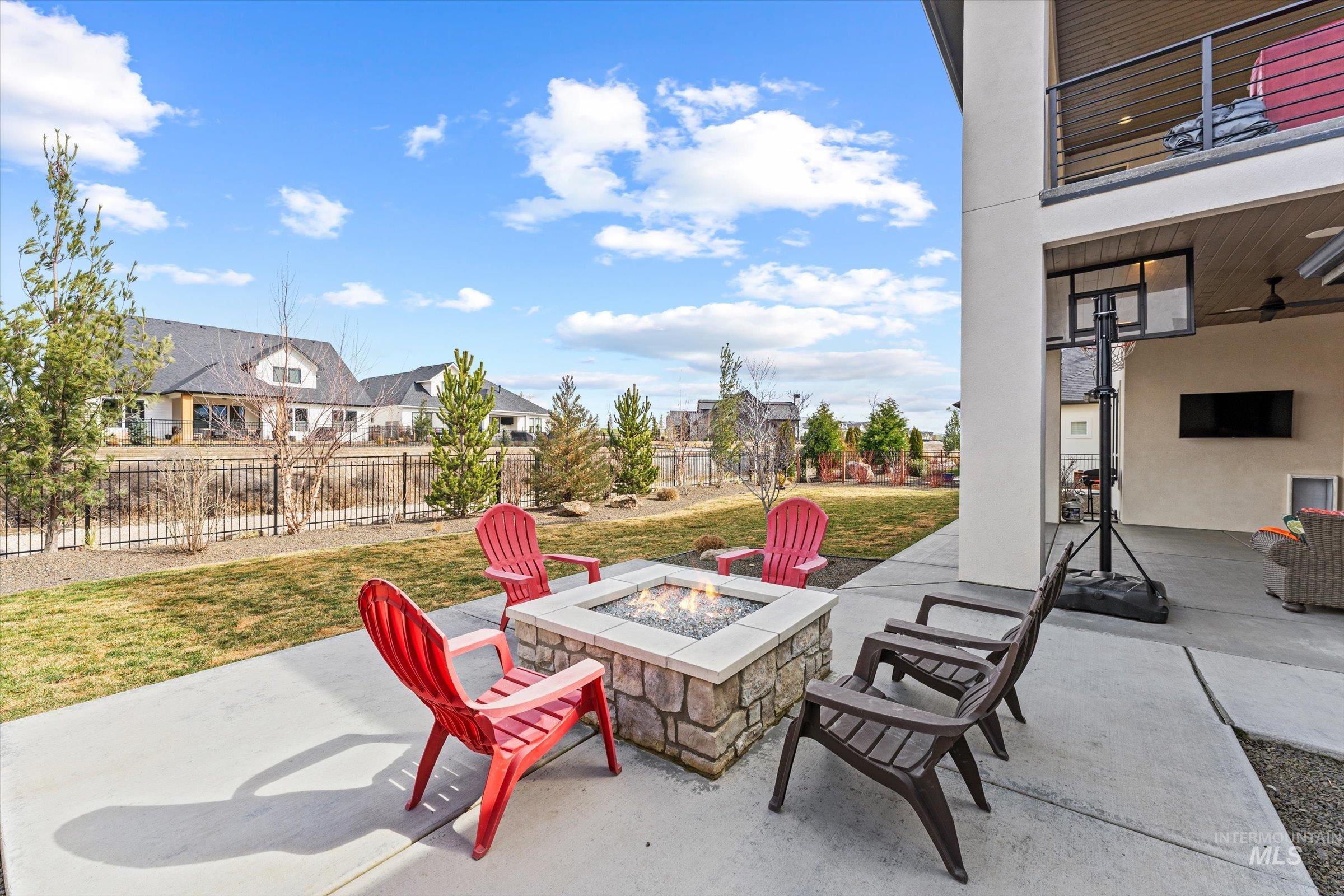 Fenced backyard featuring a patio area, a fire pit, and a residential view