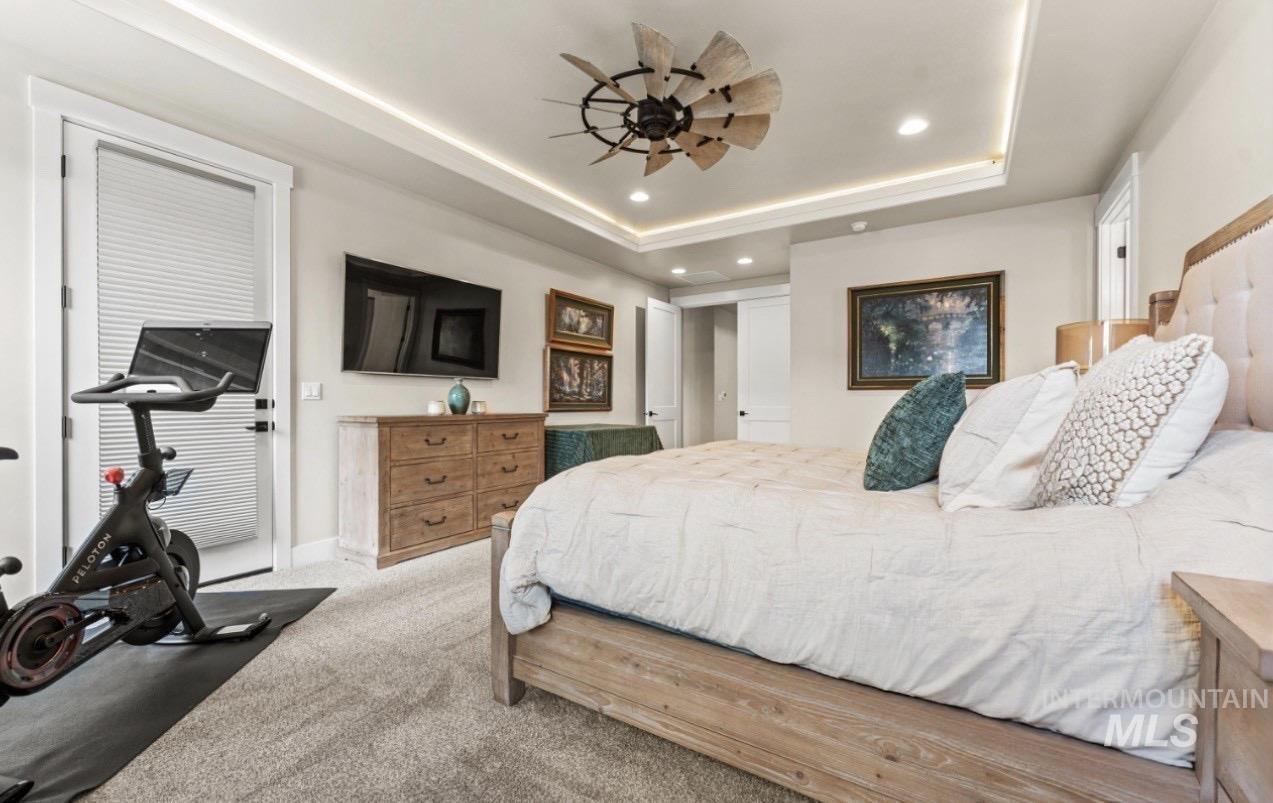 Carpeted bedroom featuring recessed lighting, a ceiling fan, and a tray ceiling