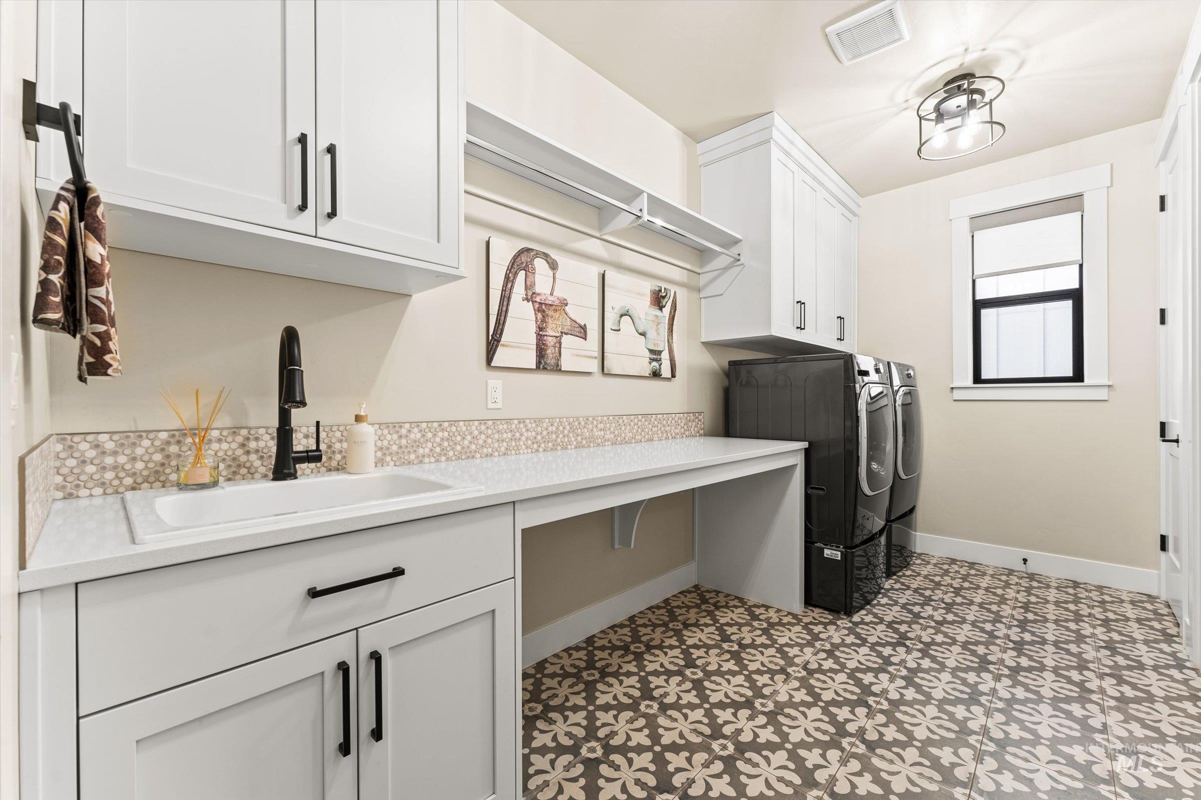 Laundry room featuring washer and dryer, cabinet space, and light floors