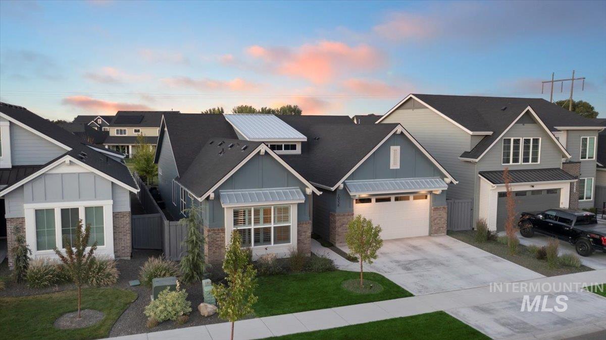 Craftsman inspired home with board and batten siding, driveway, a residential view, and an attached garage