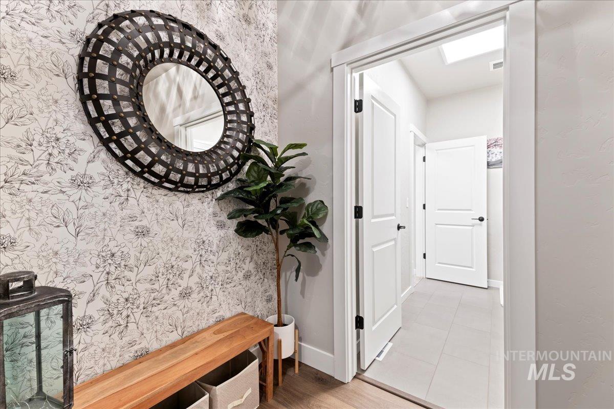 Corridor featuring light tile patterned flooring and a skylight