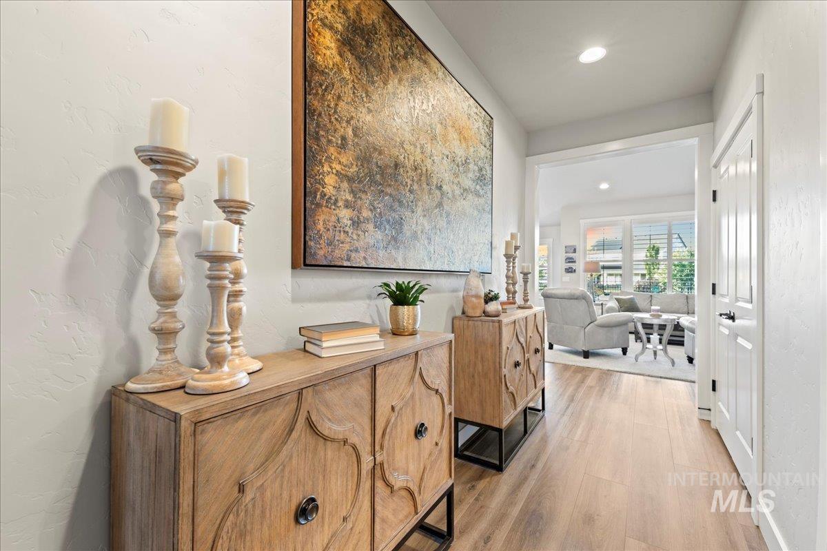 Hallway featuring light wood-type flooring, recessed lighting, and a textured wall