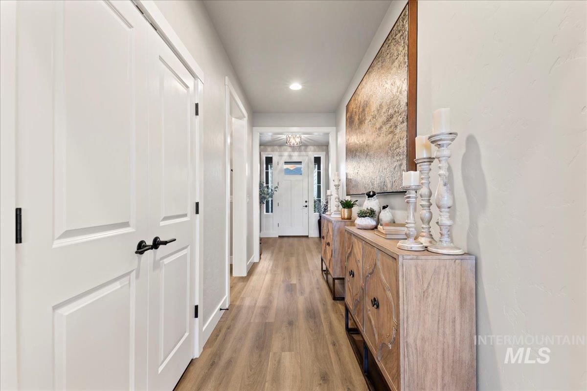 Corridor with light wood-type flooring and recessed lighting