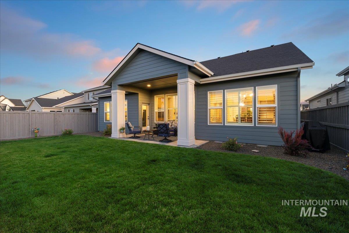 Back of property at dusk featuring a patio area and a fenced backyard