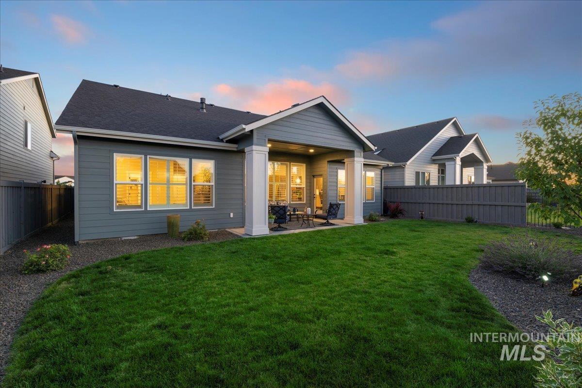 Rear view of house with a patio, a fenced backyard, and roof with shingles