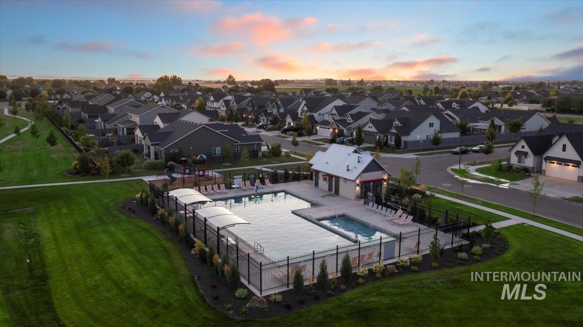 Aerial view at dusk of view of pool and a residential view