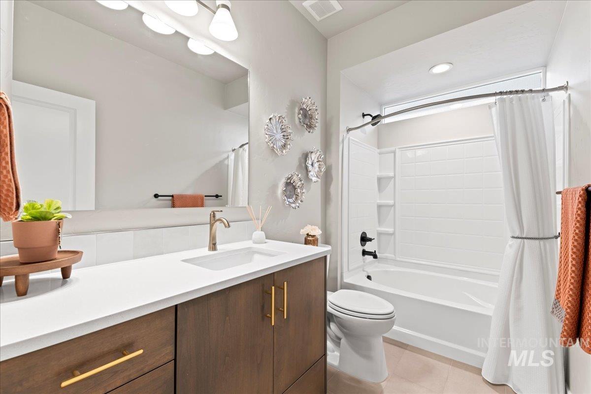 Bathroom with shower / tub combo with curtain, vanity, and light tile patterned flooring
