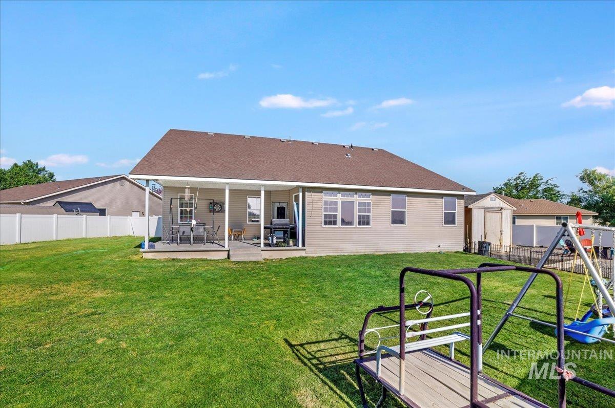 Rear view of property with a playground and a patio area