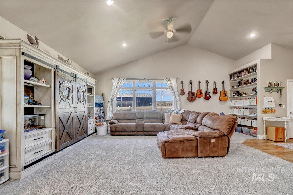 Living area with a ceiling fan, carpet flooring, vaulted ceiling, and recessed lighting