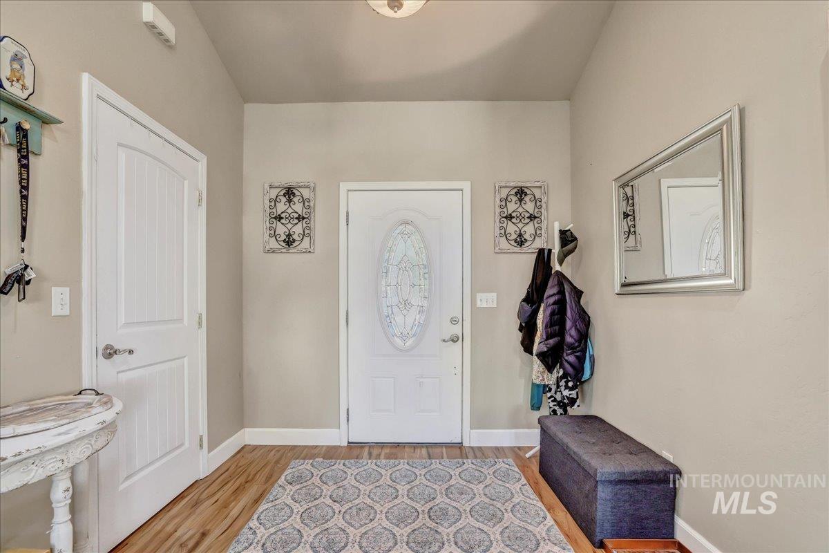 Foyer entrance with light wood finished floors and baseboards