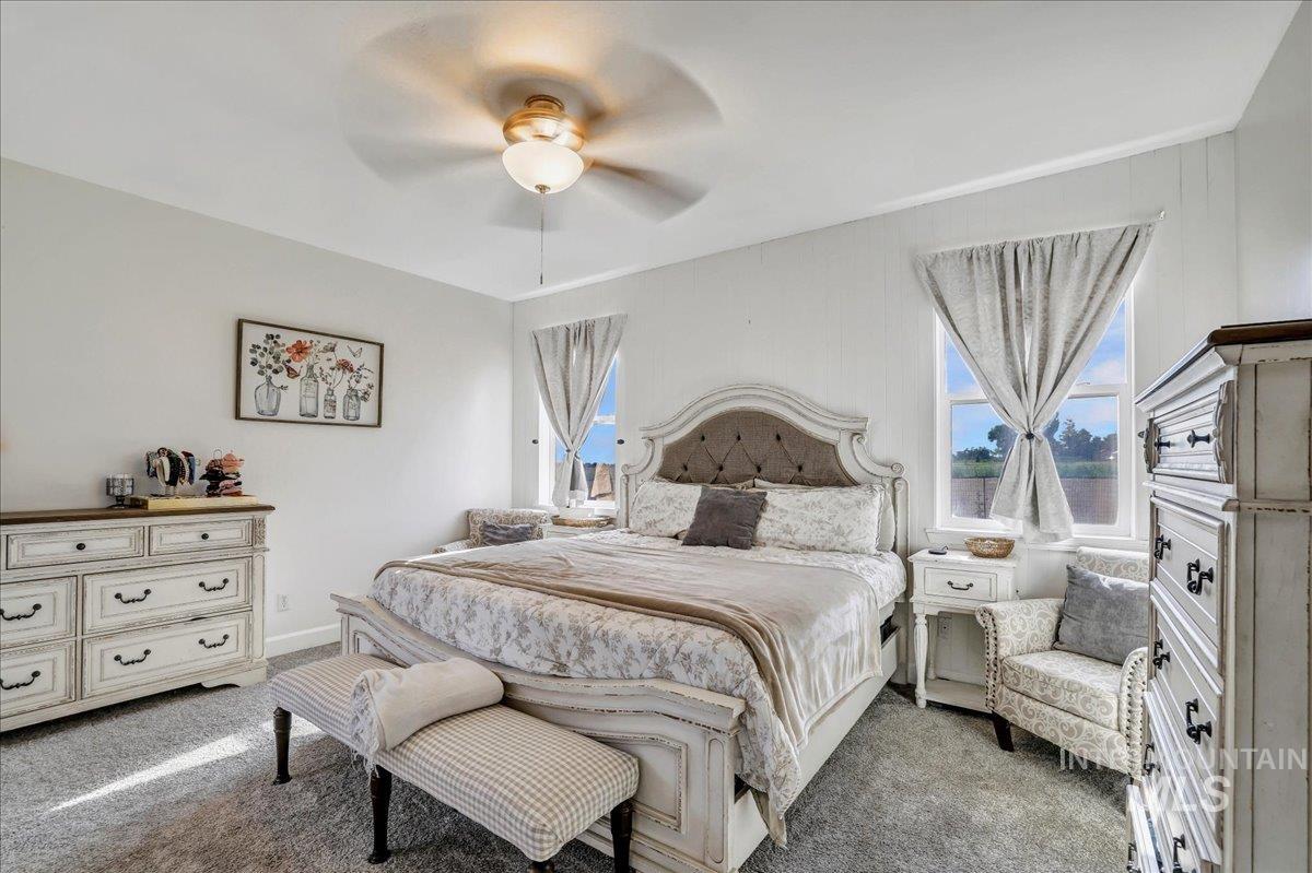 Carpeted bedroom featuring ceiling fan