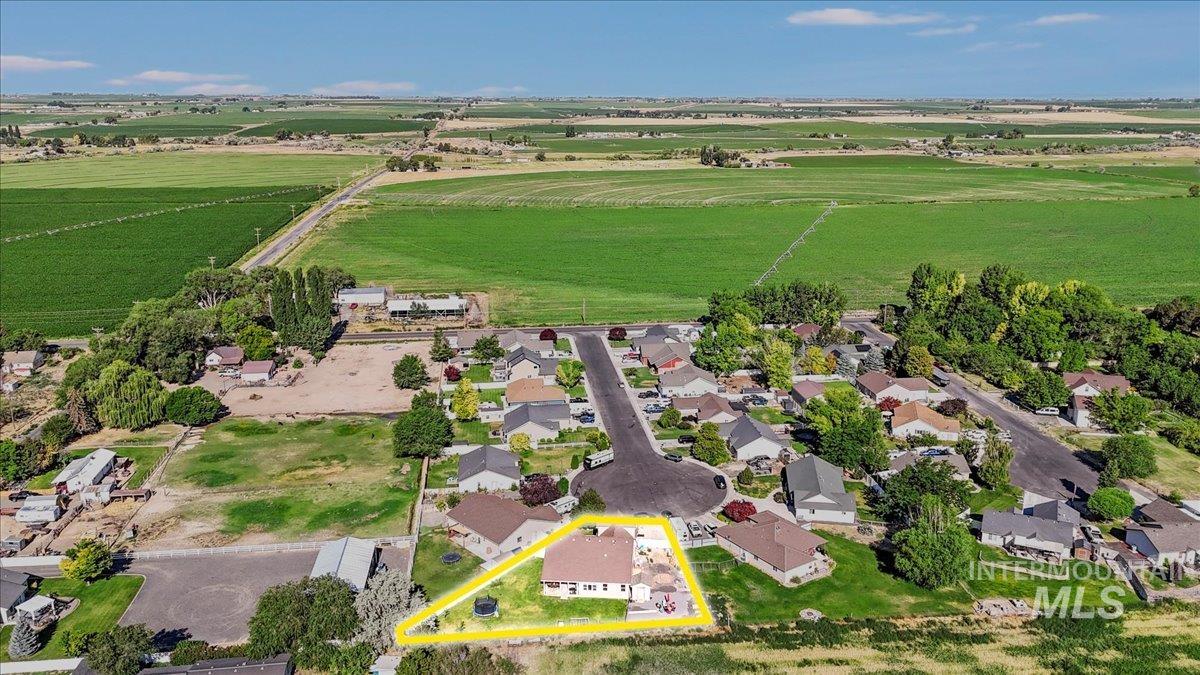 Aerial view of sparsely populated area with property parcel outlined and nearby suburban area