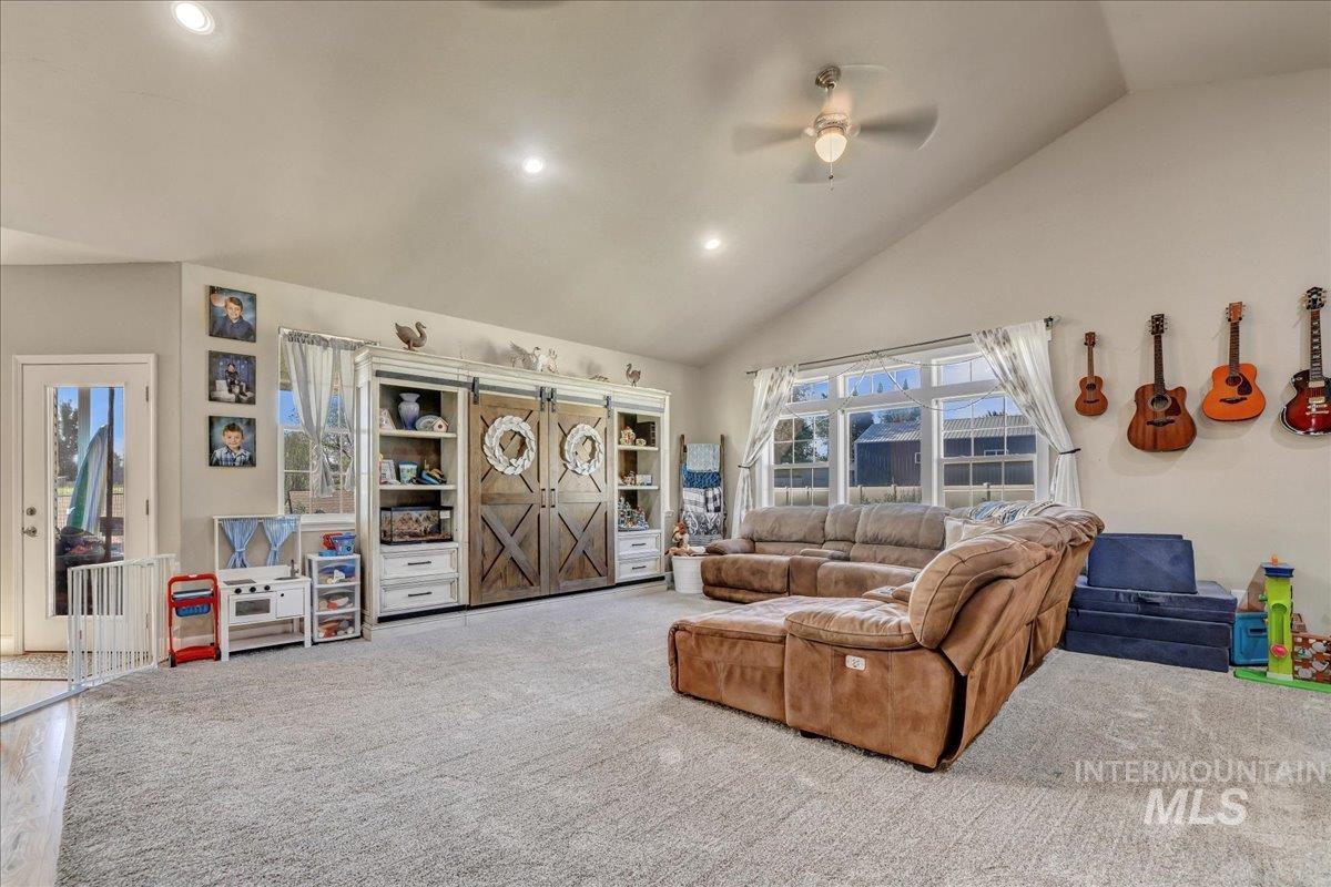 Living area featuring a ceiling fan, high vaulted ceiling, carpet, and recessed lighting
