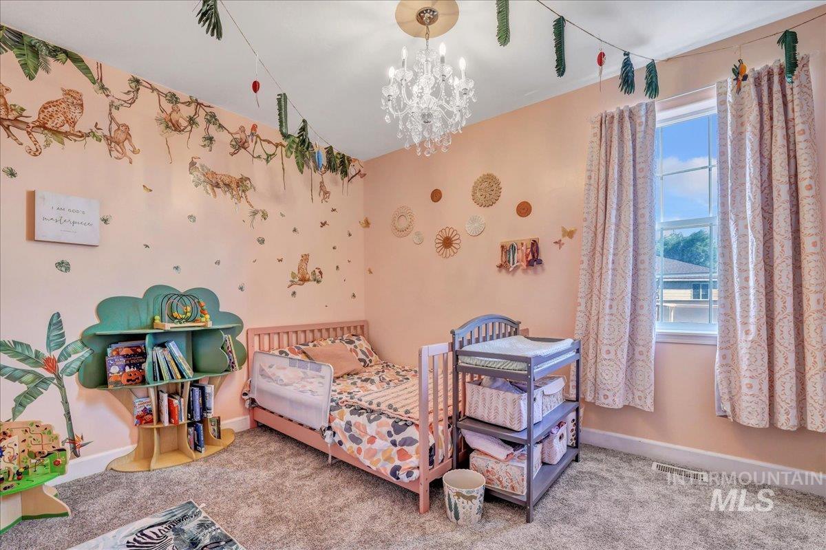 Bedroom with carpet and a chandelier