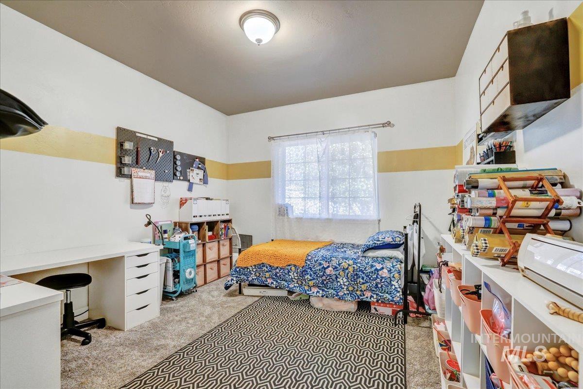 Bedroom featuring carpet and an office area