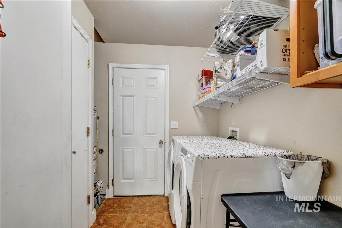 Laundry area with washer and dryer and light tile patterned flooring