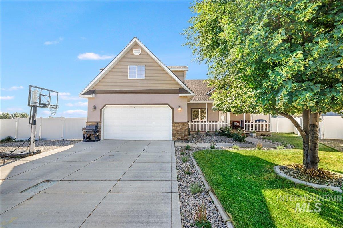 Traditional-style house with covered porch, concrete driveway, stone siding, stucco siding, and a shingled roof