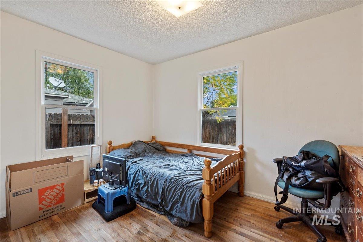 Bedroom featuring wood finished floors and a textured ceiling