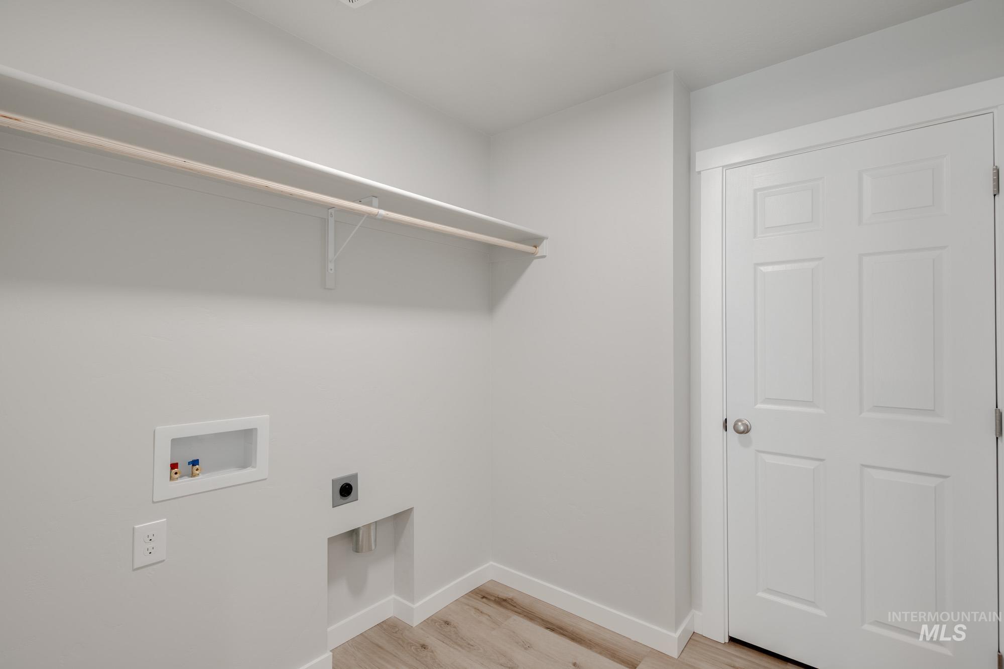 Laundry room featuring light wood finished floors, hookup for a washing machine, and electric dryer hookup