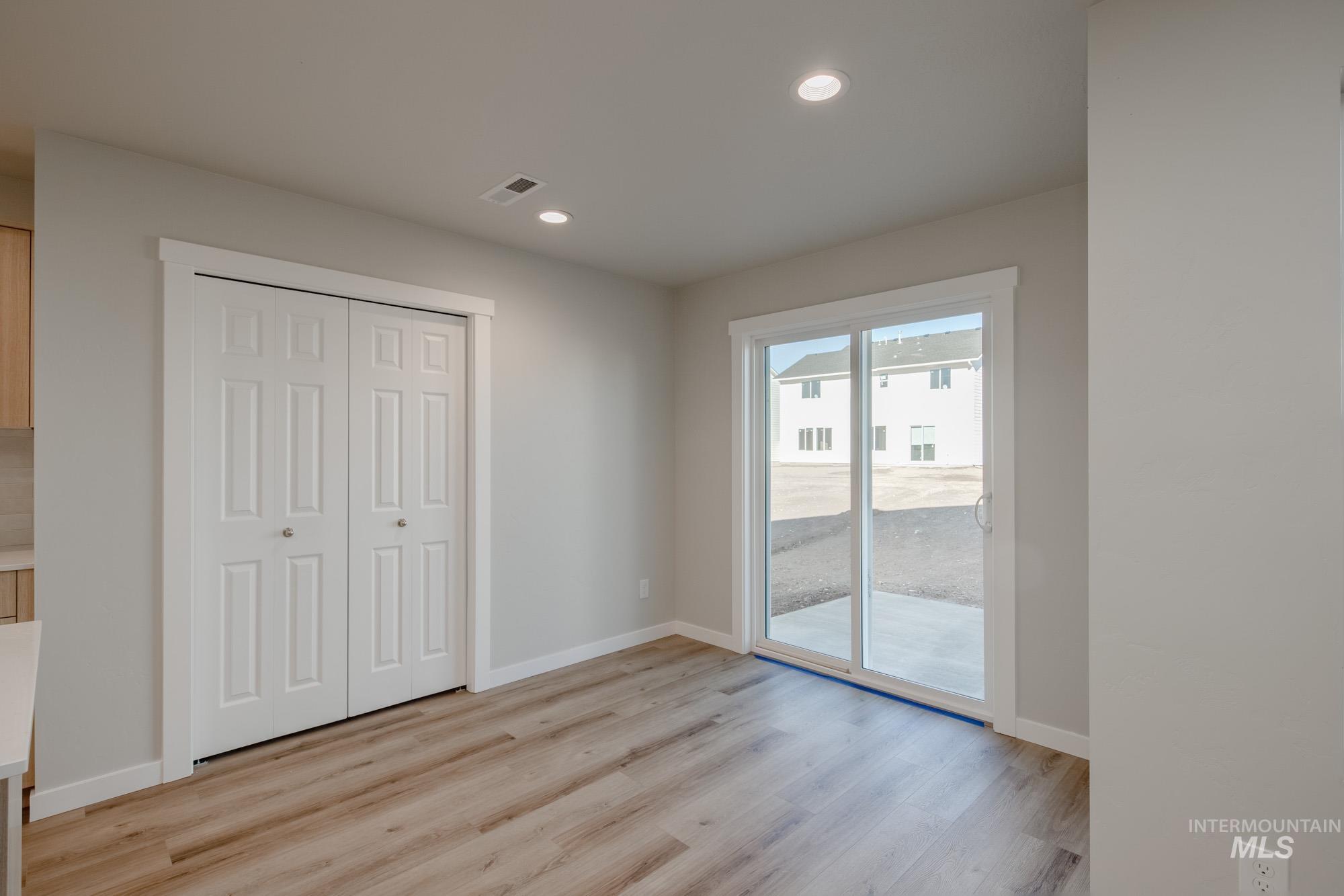 Unfurnished bedroom featuring access to exterior, light wood-type flooring, a closet, and recessed lighting