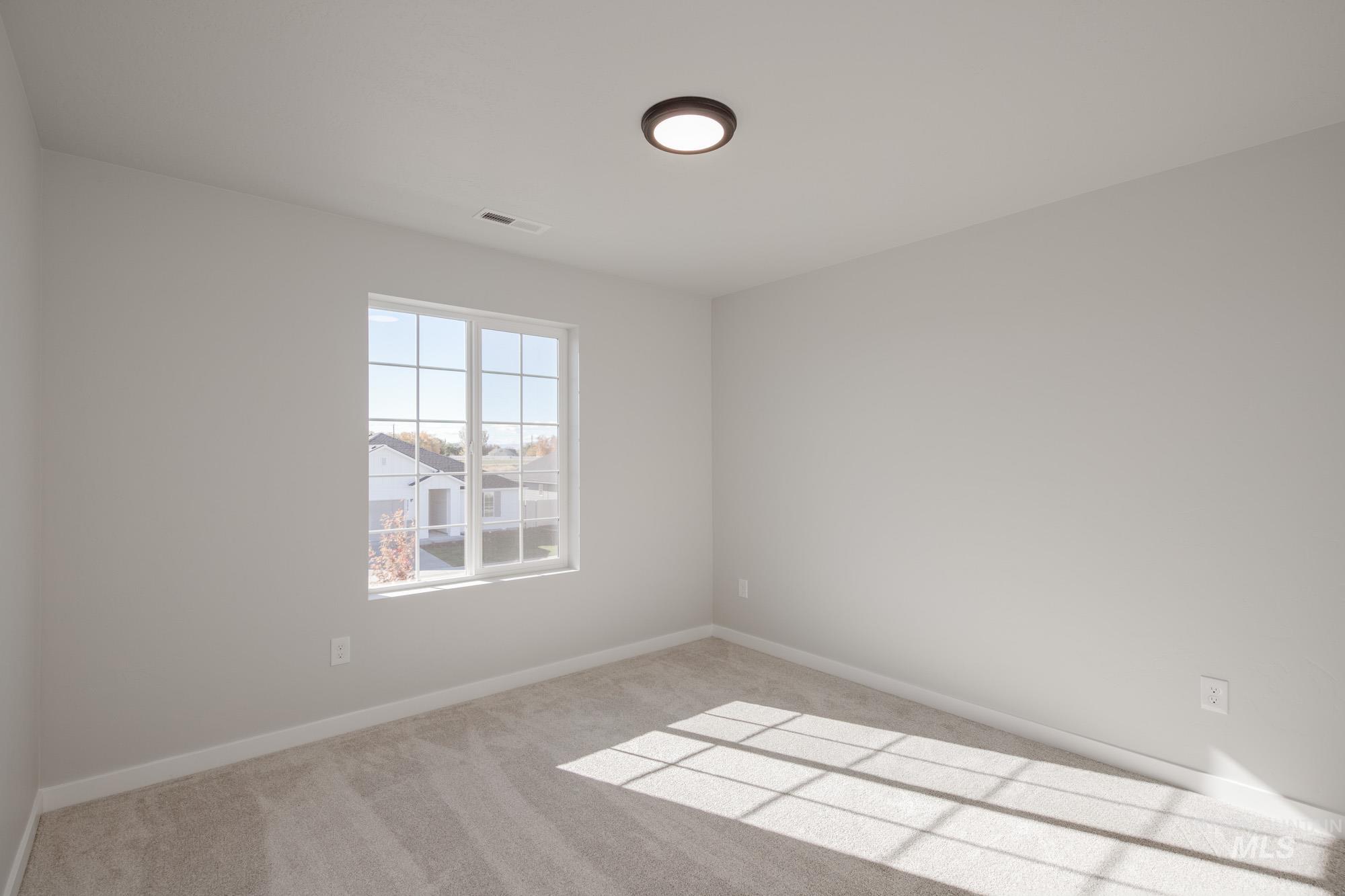 Carpeted empty room with baseboards