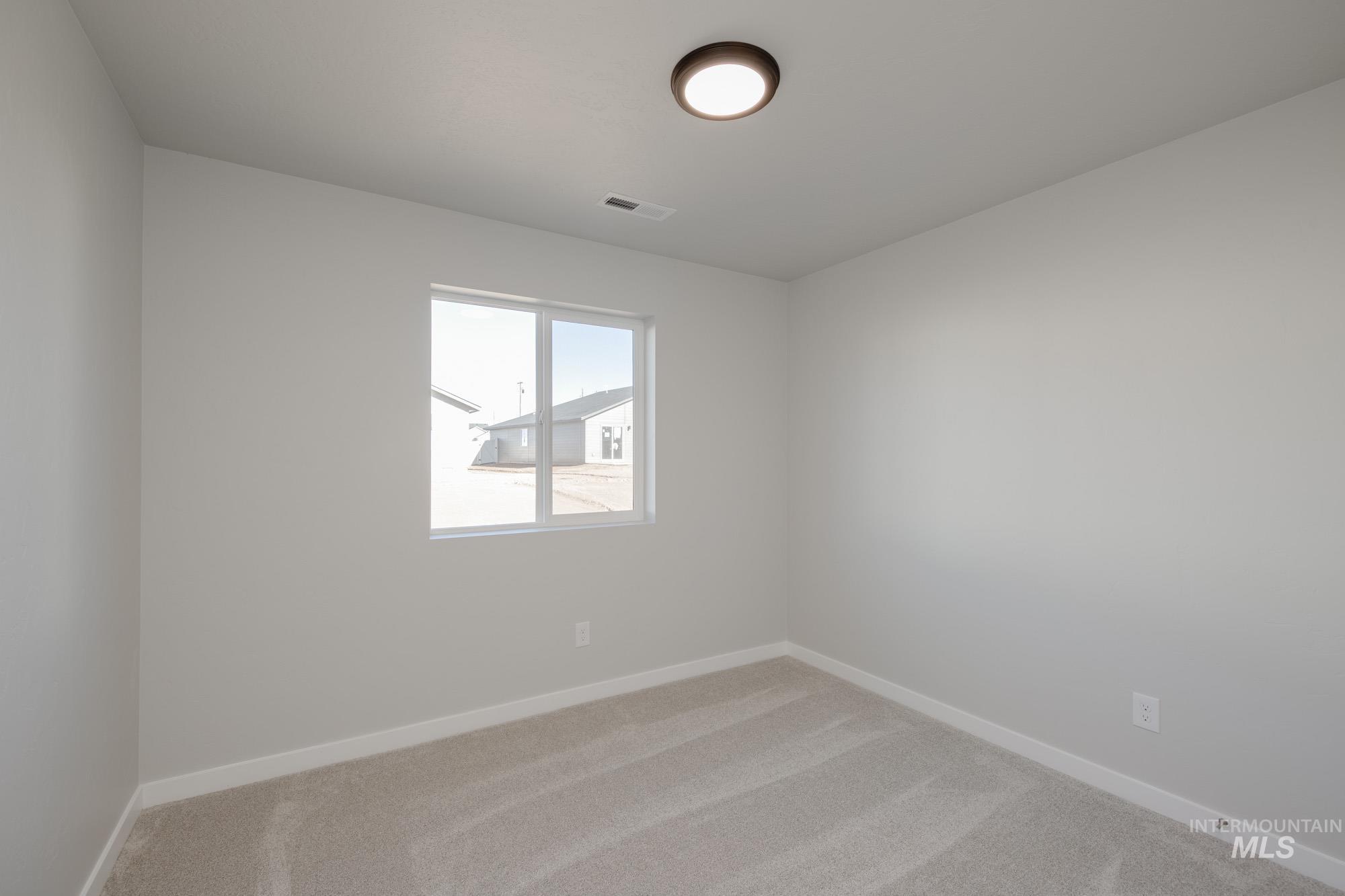 Unfurnished room featuring light colored carpet and baseboards