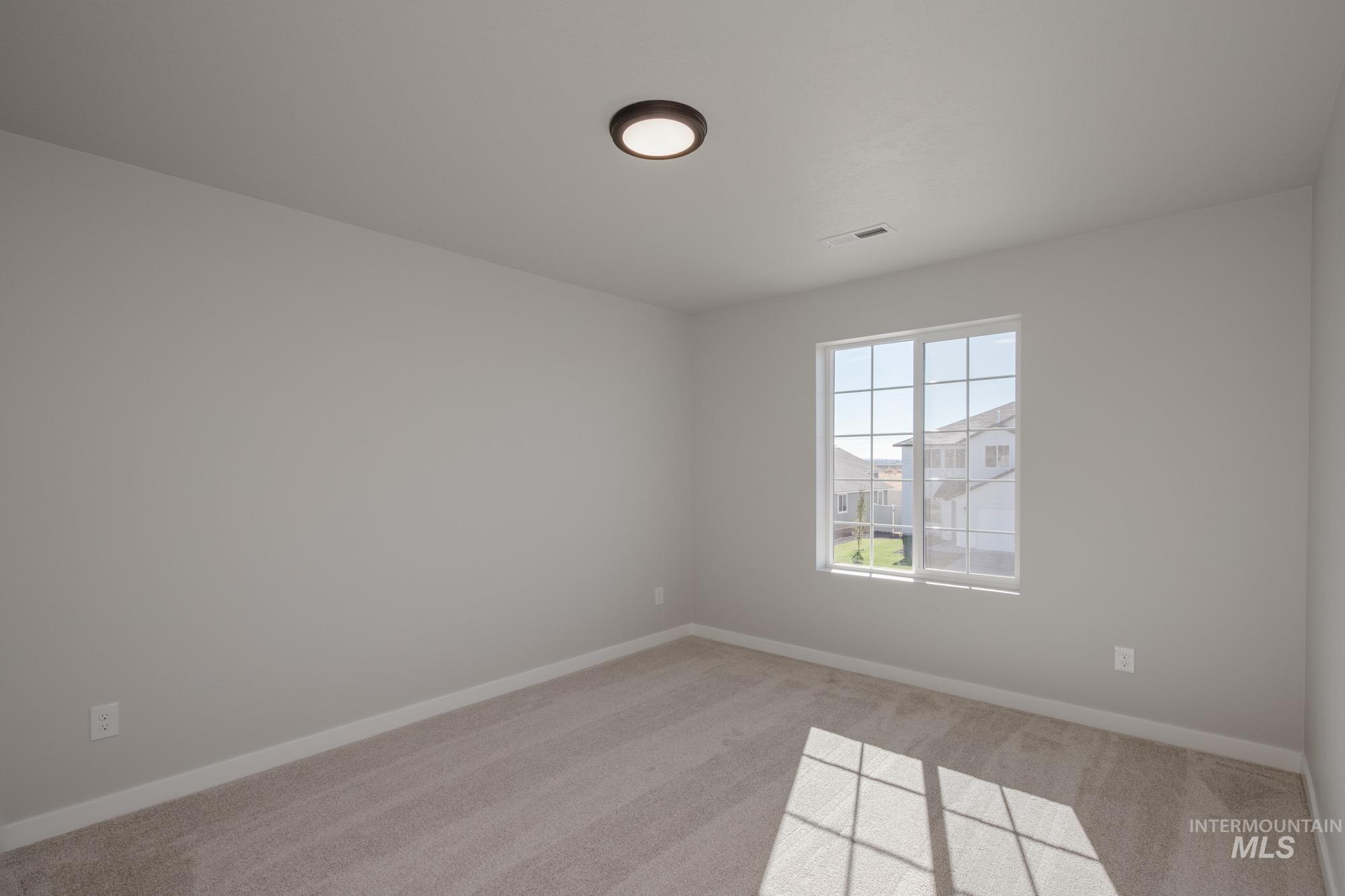 Unfurnished room featuring light colored carpet and baseboards