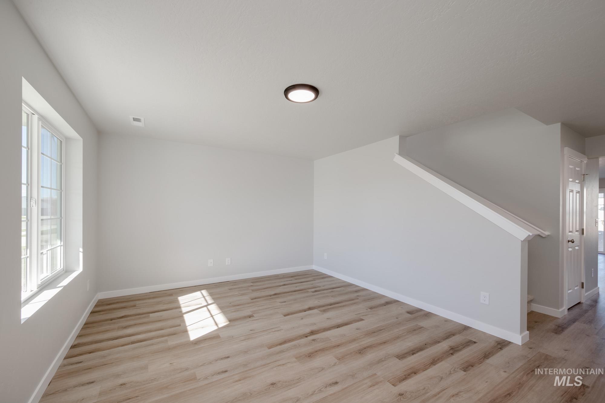 Empty room with light wood finished floors and stairs