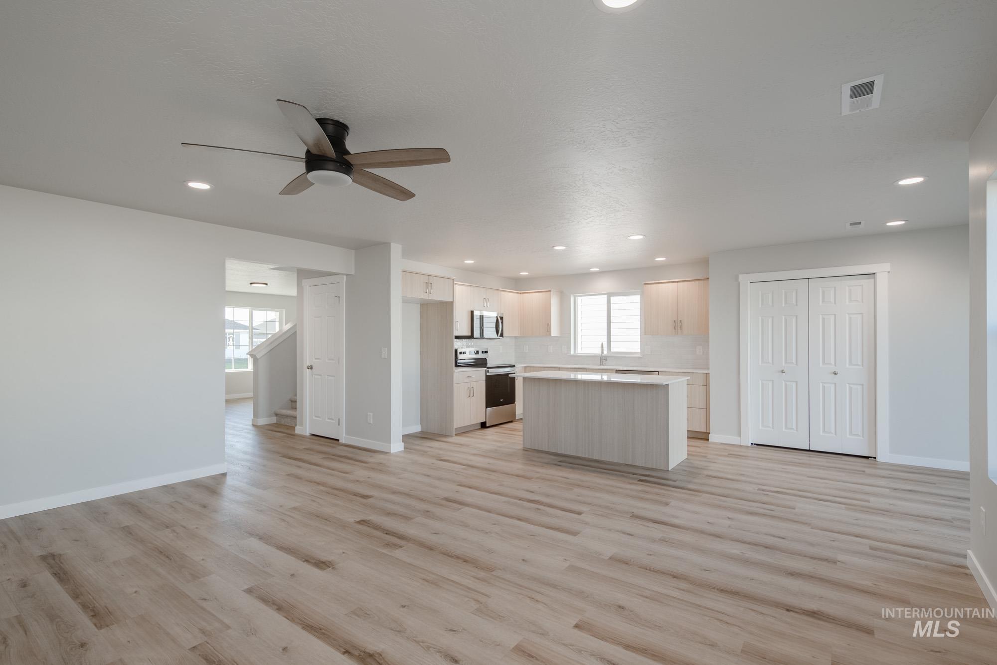 Kitchen featuring open floor plan, a kitchen island, healthy amount of natural light, stainless steel appliances, and recessed lighting