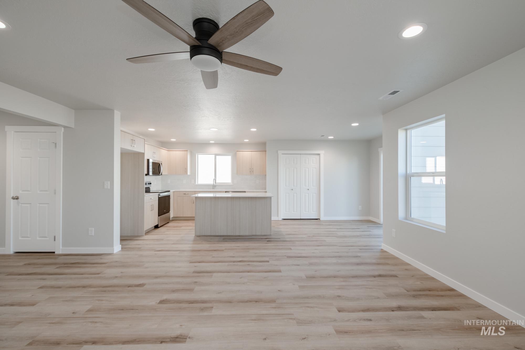 Kitchen with open floor plan, recessed lighting, light countertops, light wood finished floors, and stainless steel appliances
