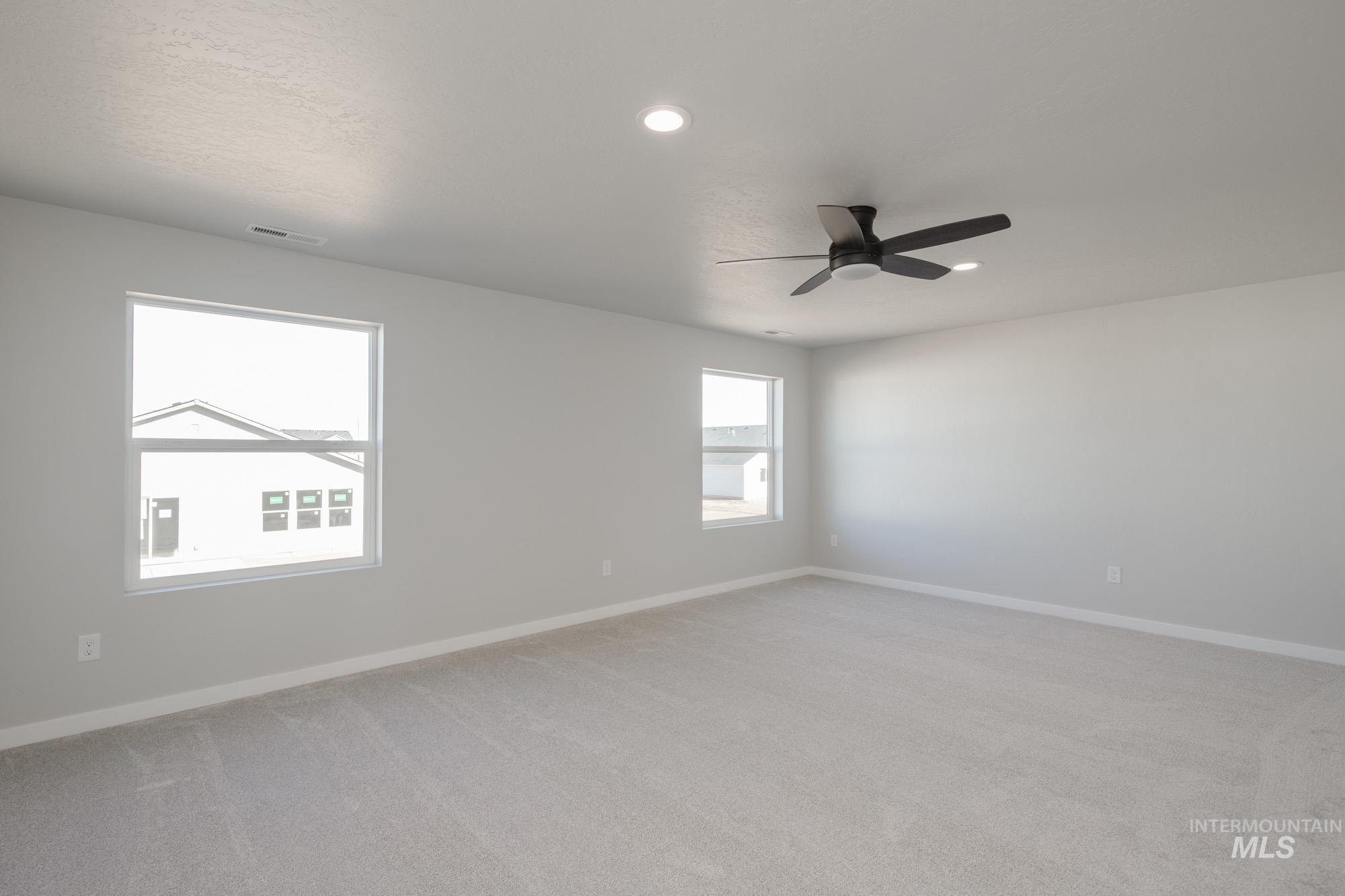 Spare room featuring light carpet, recessed lighting, and a ceiling fan