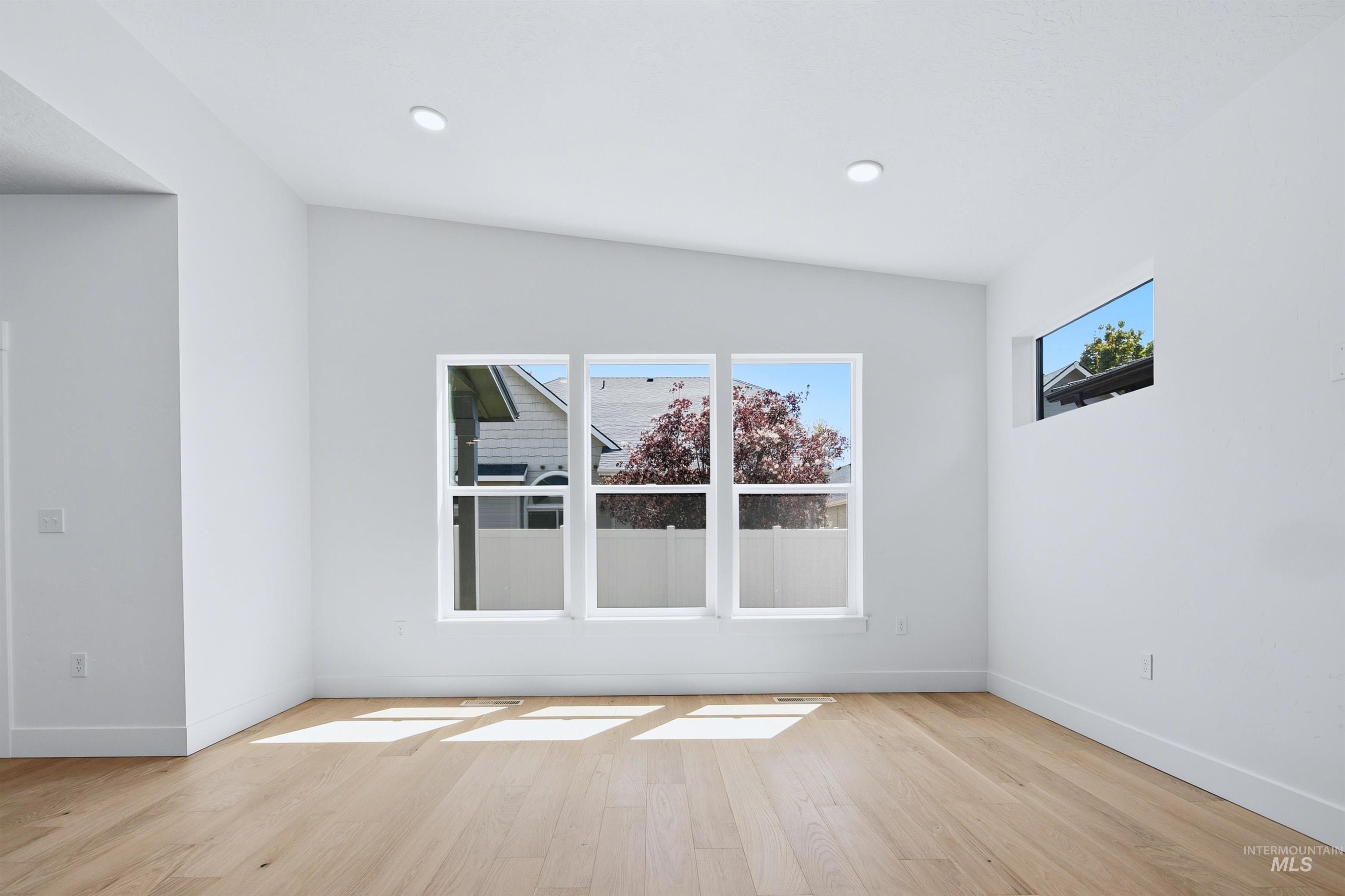 Bright interior space featuring wood-finish flooring, white walls, and recessed lighting