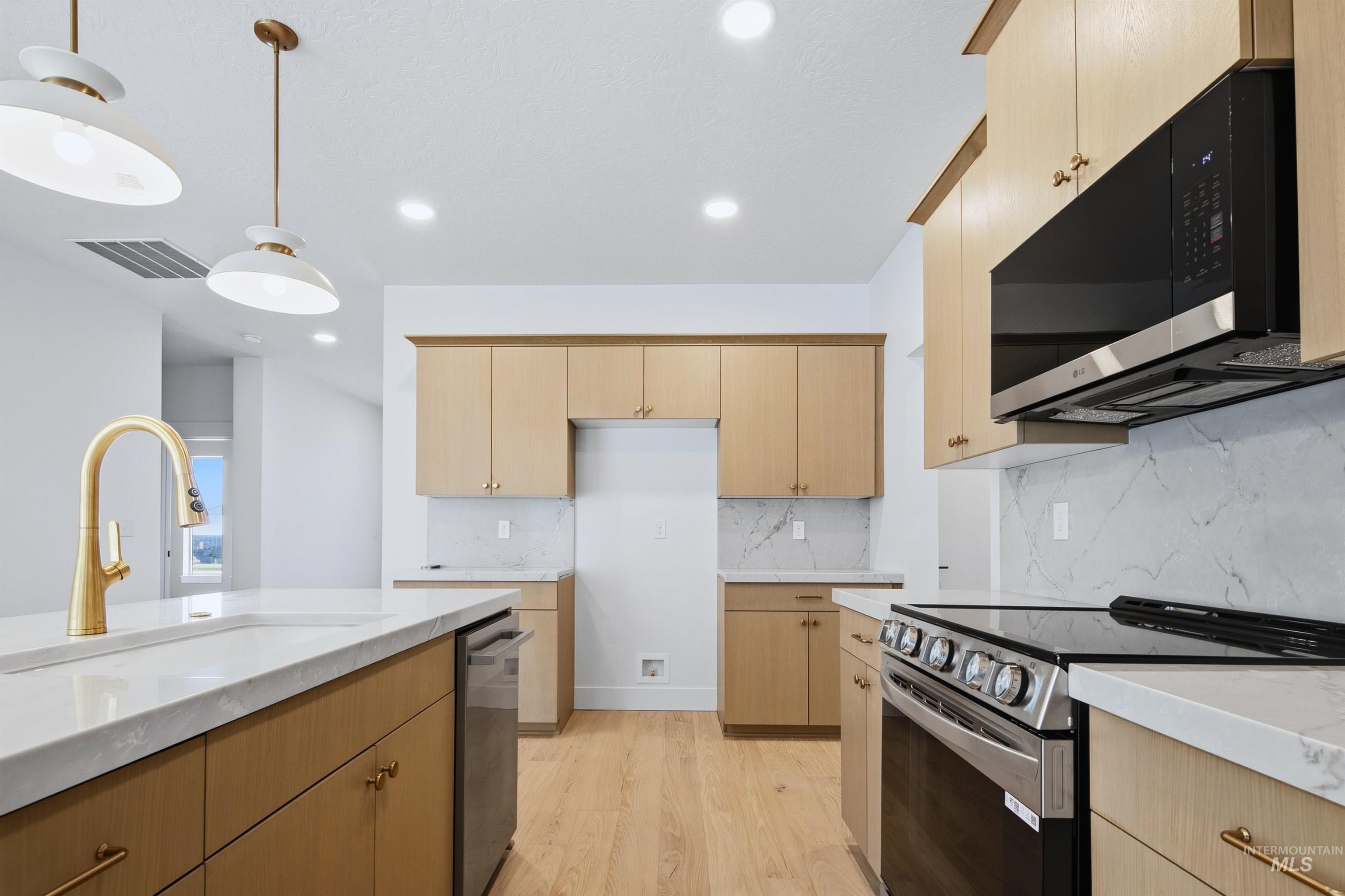 Contemporary kitchen featuring wood-finish cabinetry, white marble-look countertops, and a white tile backsplash