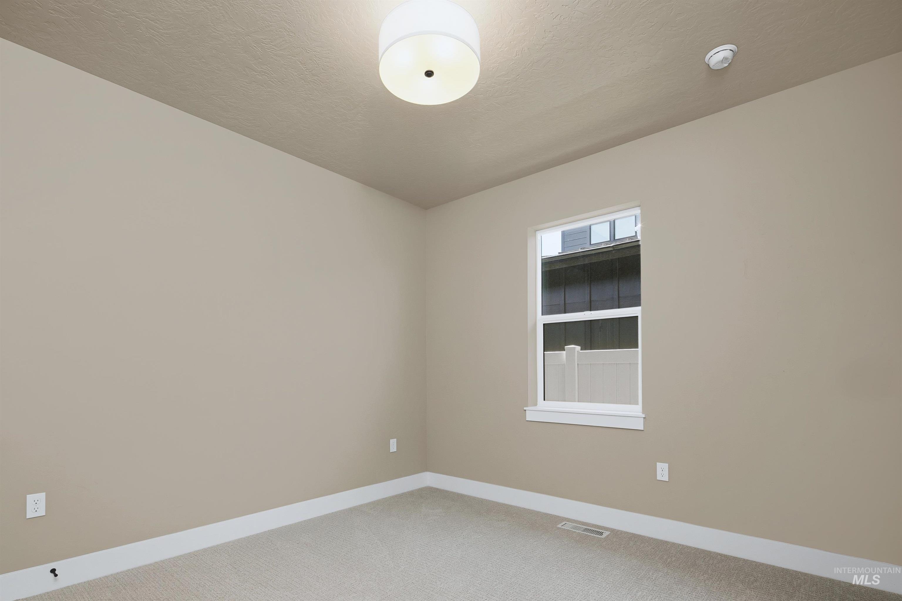 Neutral-toned walls complement the light beige carpet flooring