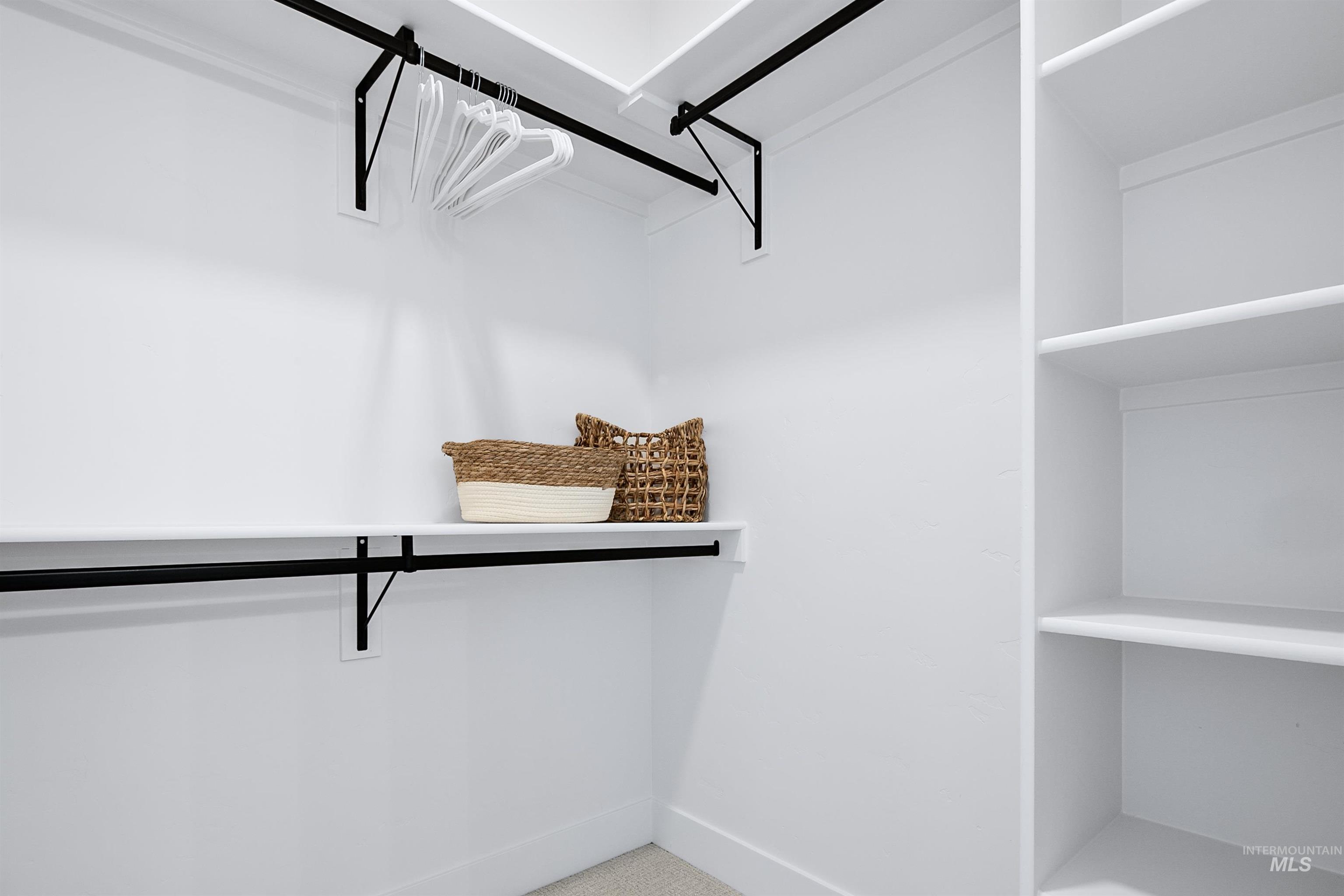 Built-in closet system featuring white shelving, black hanging rods, and integrated shelving units