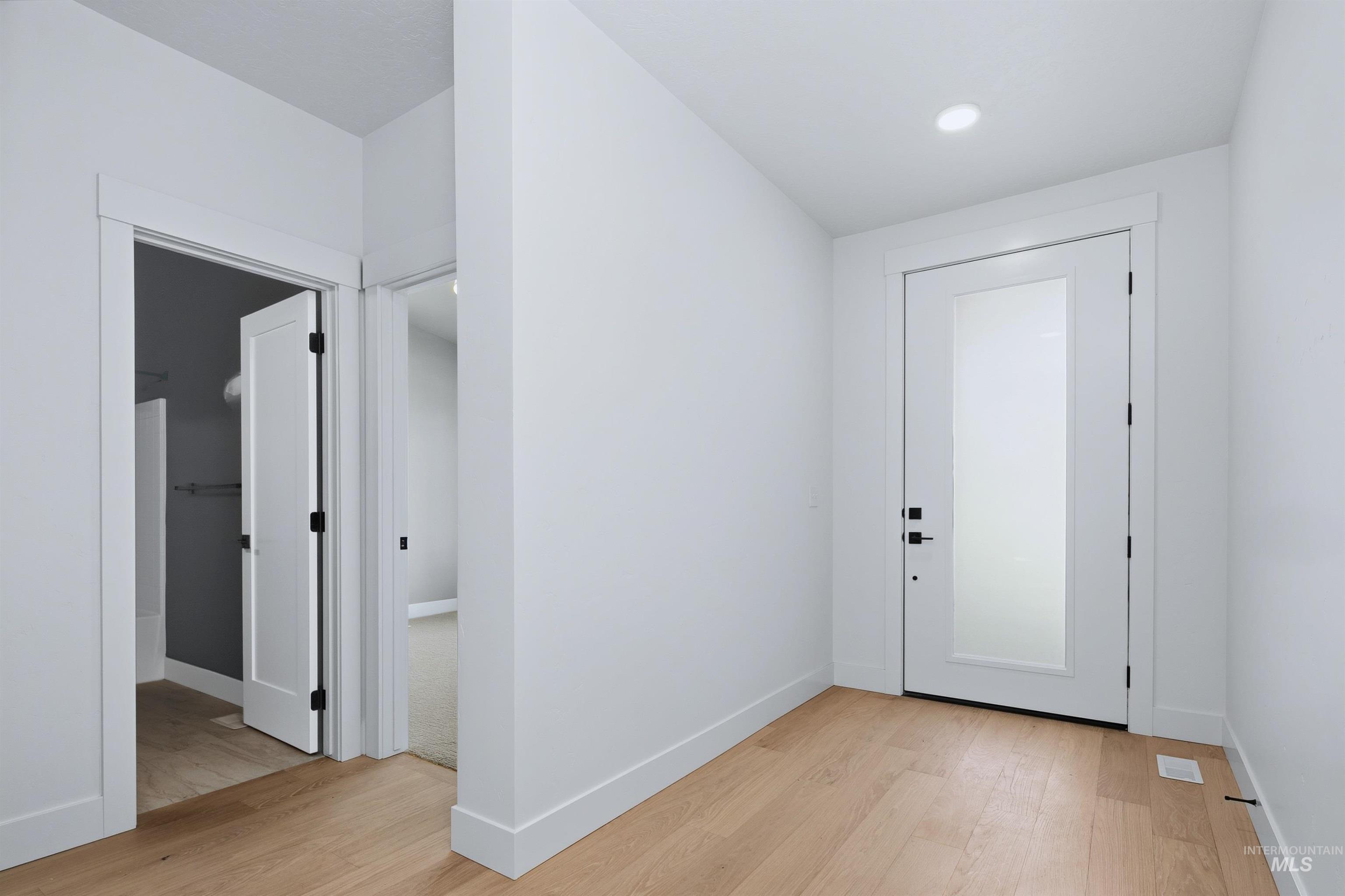 Entryway featuring light wood-finish flooring, white walls, and bright white trim