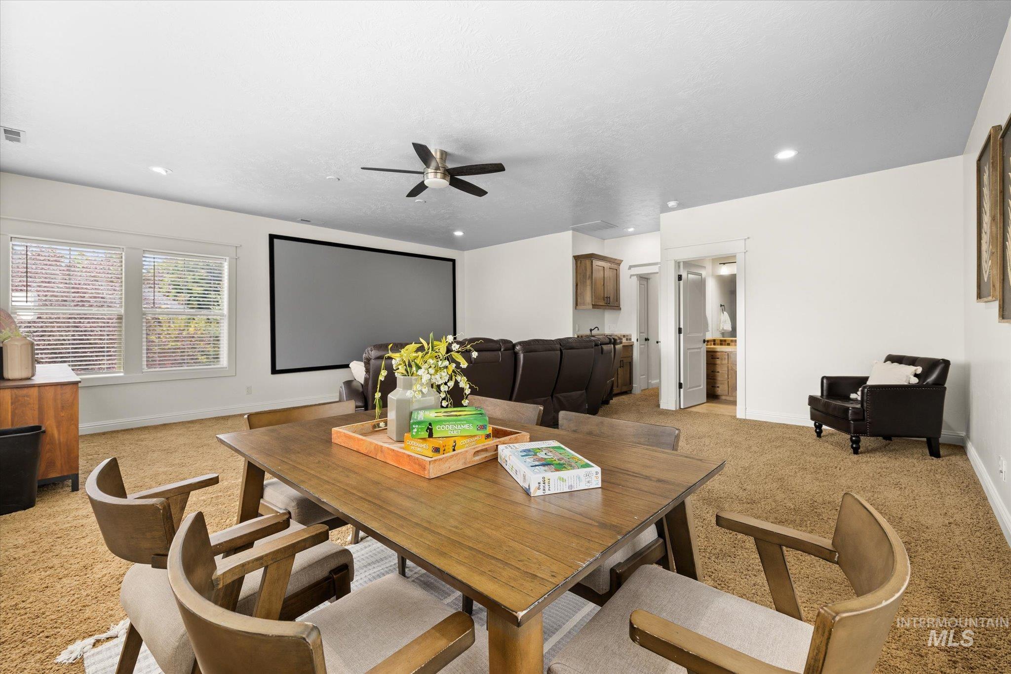 Dining room featuring light carpet, a ceiling fan, and recessed lighting