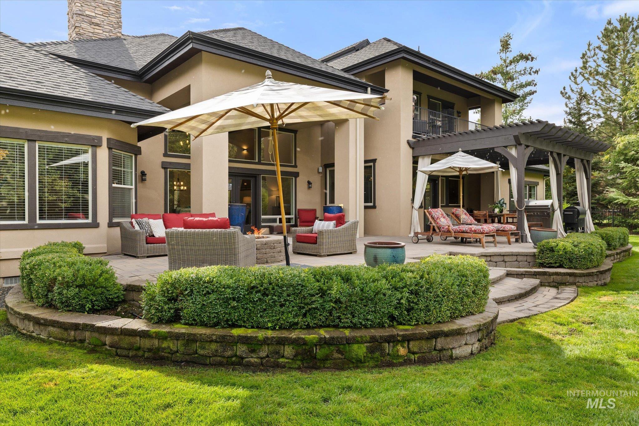 Rear view of house featuring stucco siding, a patio area, and a lawn