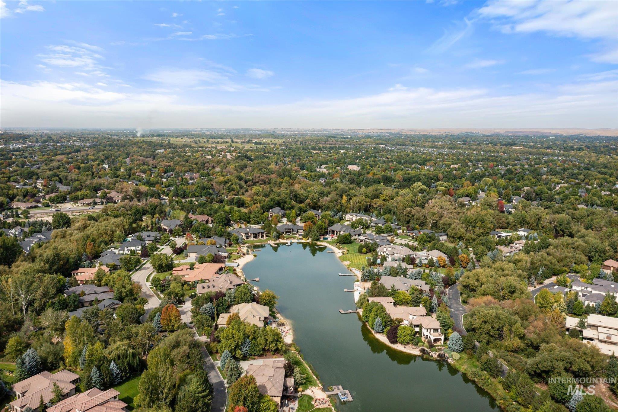 Aerial view of property's location featuring a nearby body of water and nearby suburban area