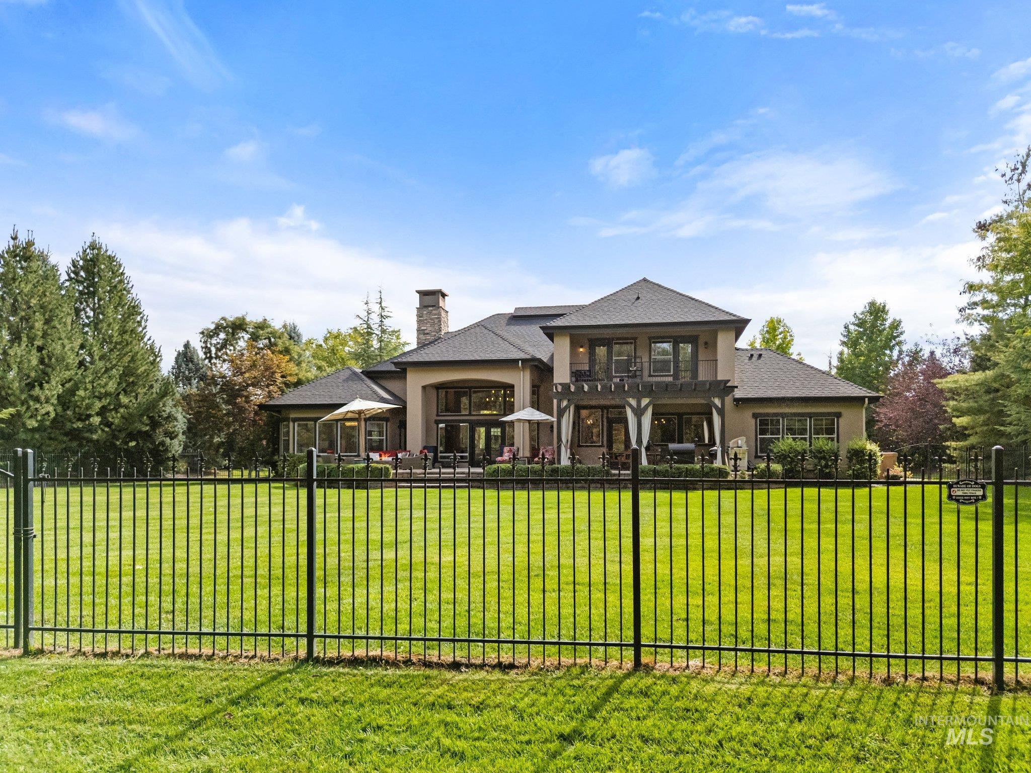 Rear view of property featuring a fenced backyard, a balcony, a chimney, and a patio area