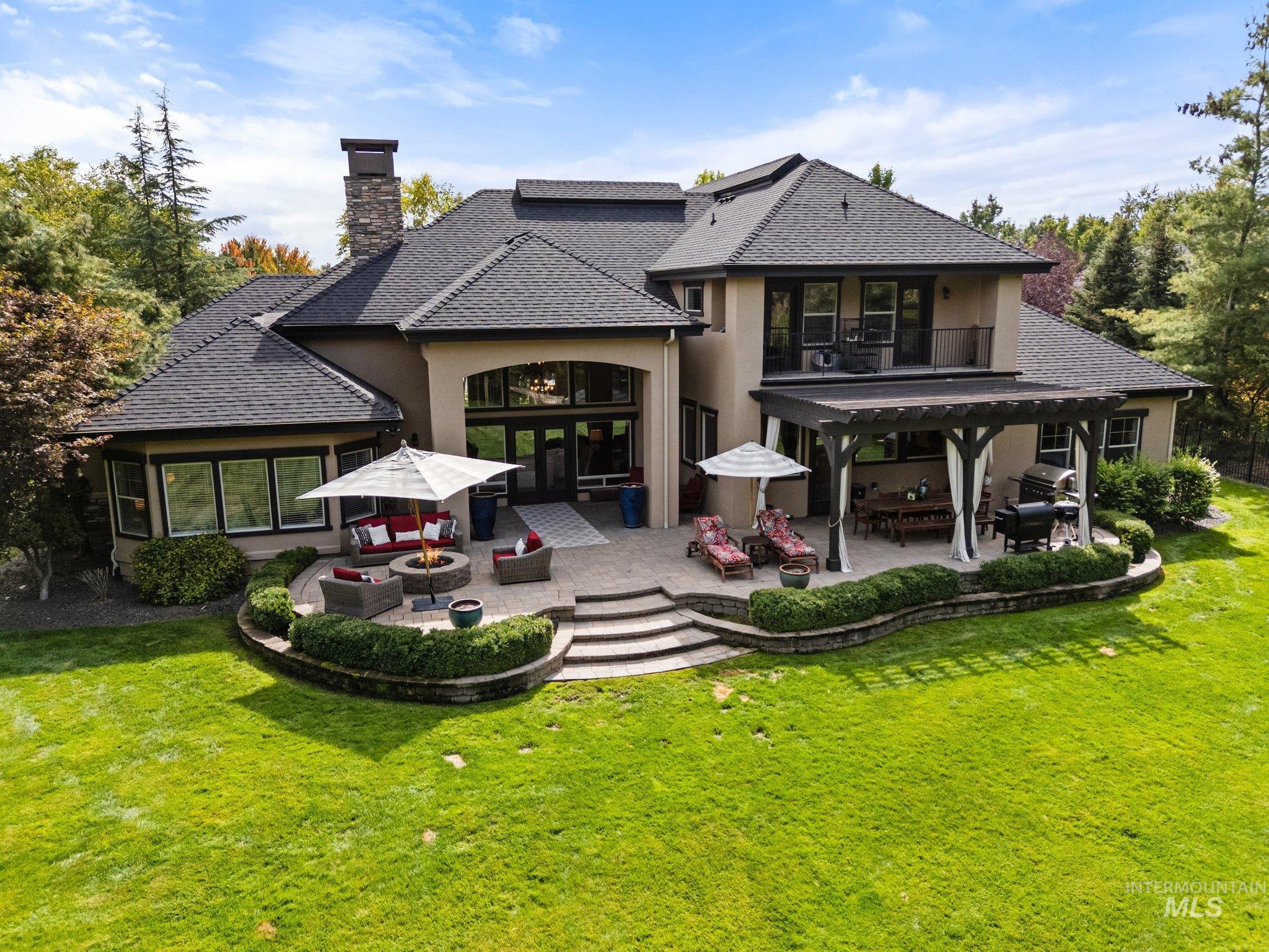 Rear view of house with outdoor lounge area, a patio area, stucco siding, and a yard