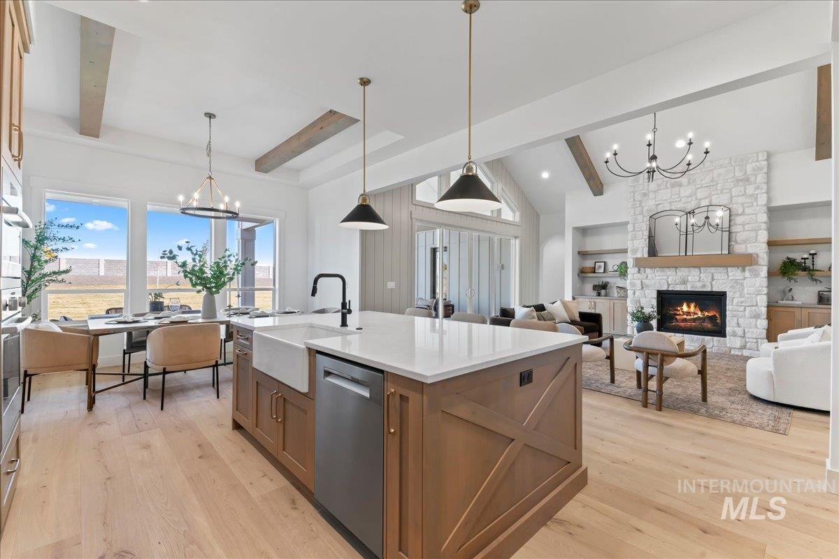 Kitchen with a chandelier, brown cabinetry, pendant lighting, and a fireplace