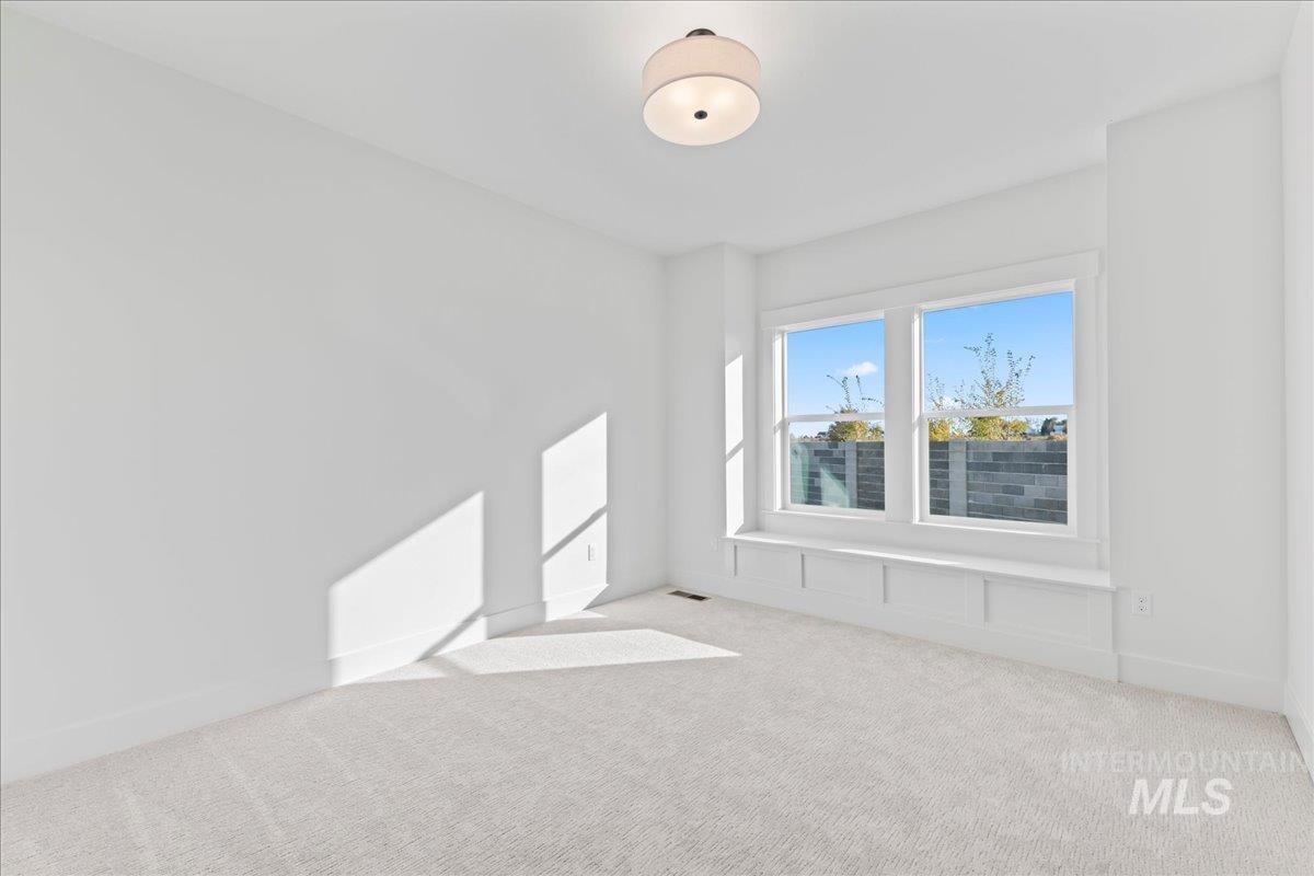 Spare room with light carpet and baseboards